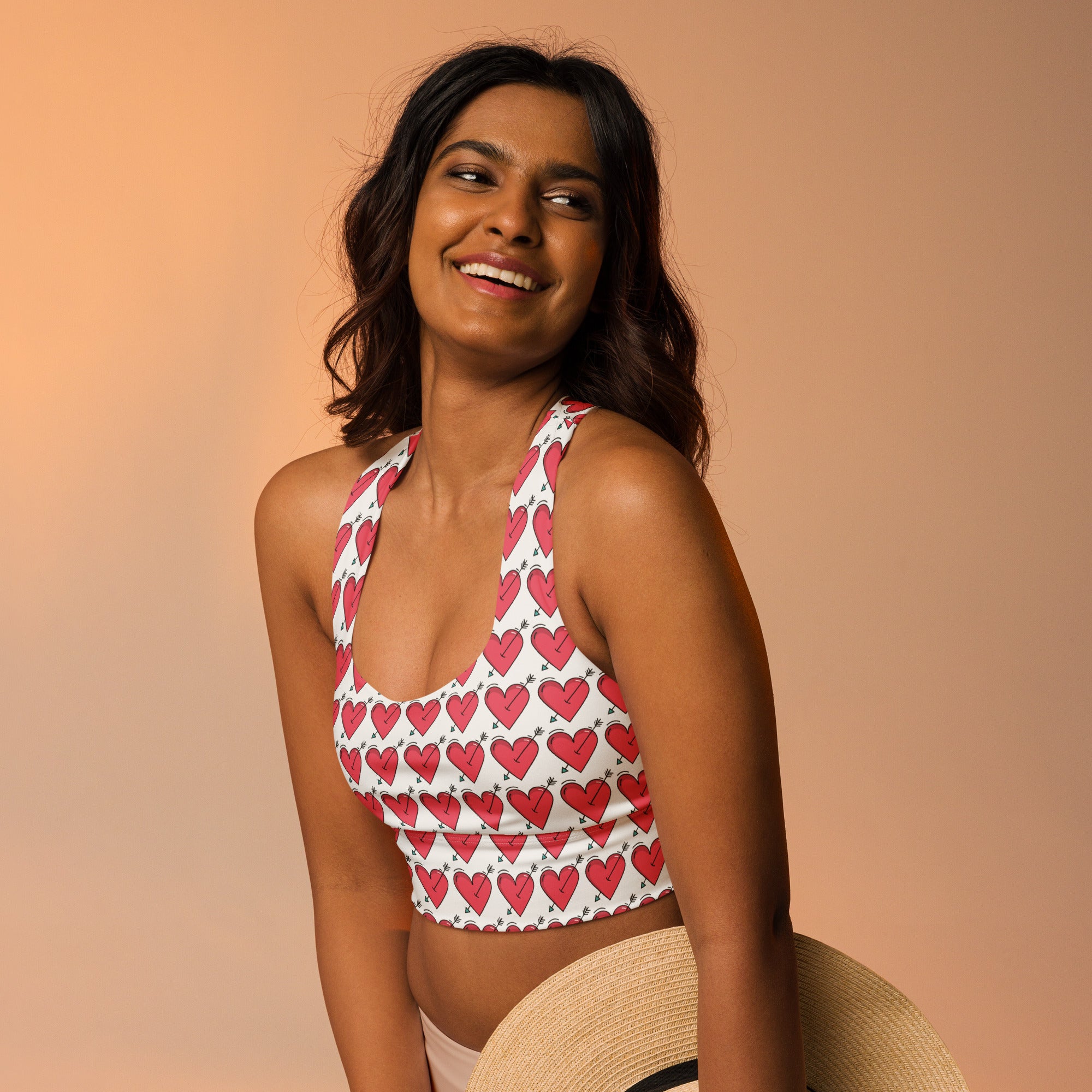 White halter top with pink heart and arrow pattern women’s valentine’s day recycled sports bra with high support