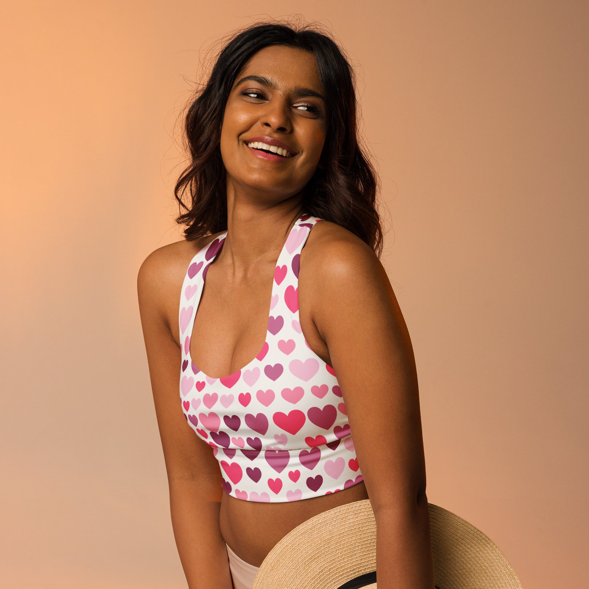 White longline sports bra with pink and purple heart pattern made from buttery soft recycled fabric for high intensity support