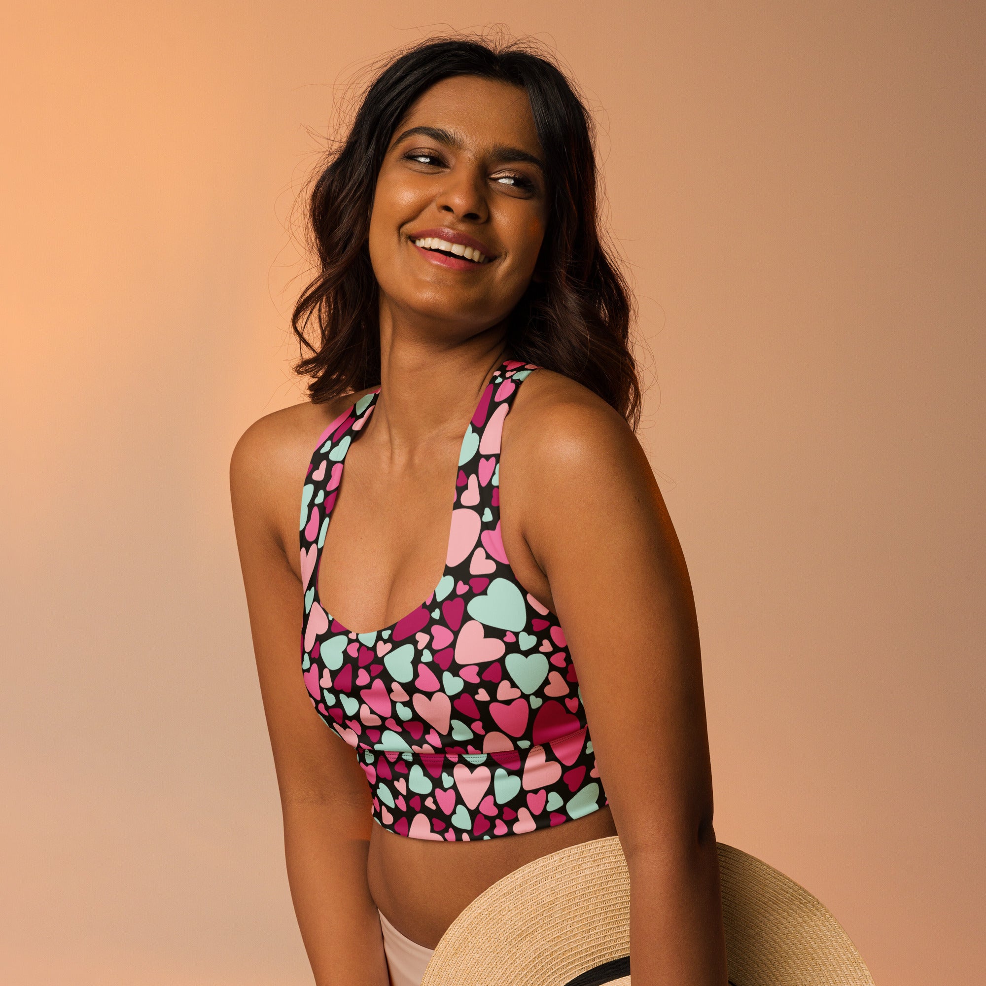 Women’s valentine’s day sports bra with vibrant pink and mint heart pattern on black base high intensity support