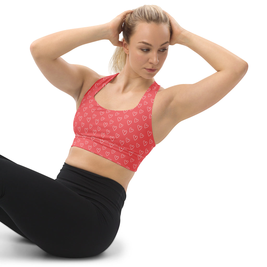 Red longline sports bra with white heart outlines made from buttery soft recycled fabric for high intensity support