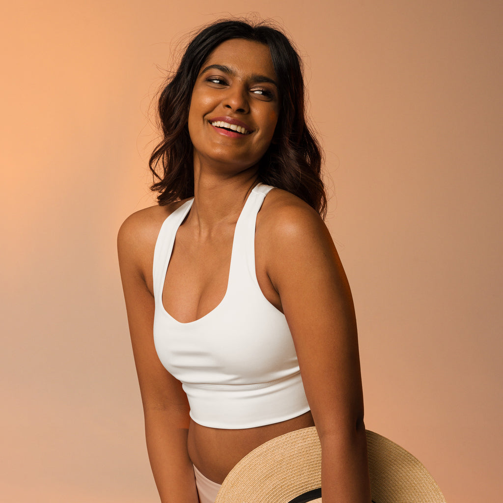 White cropped sports bra with thin straps and rounded neckline made from recycled fabric for high intensity support