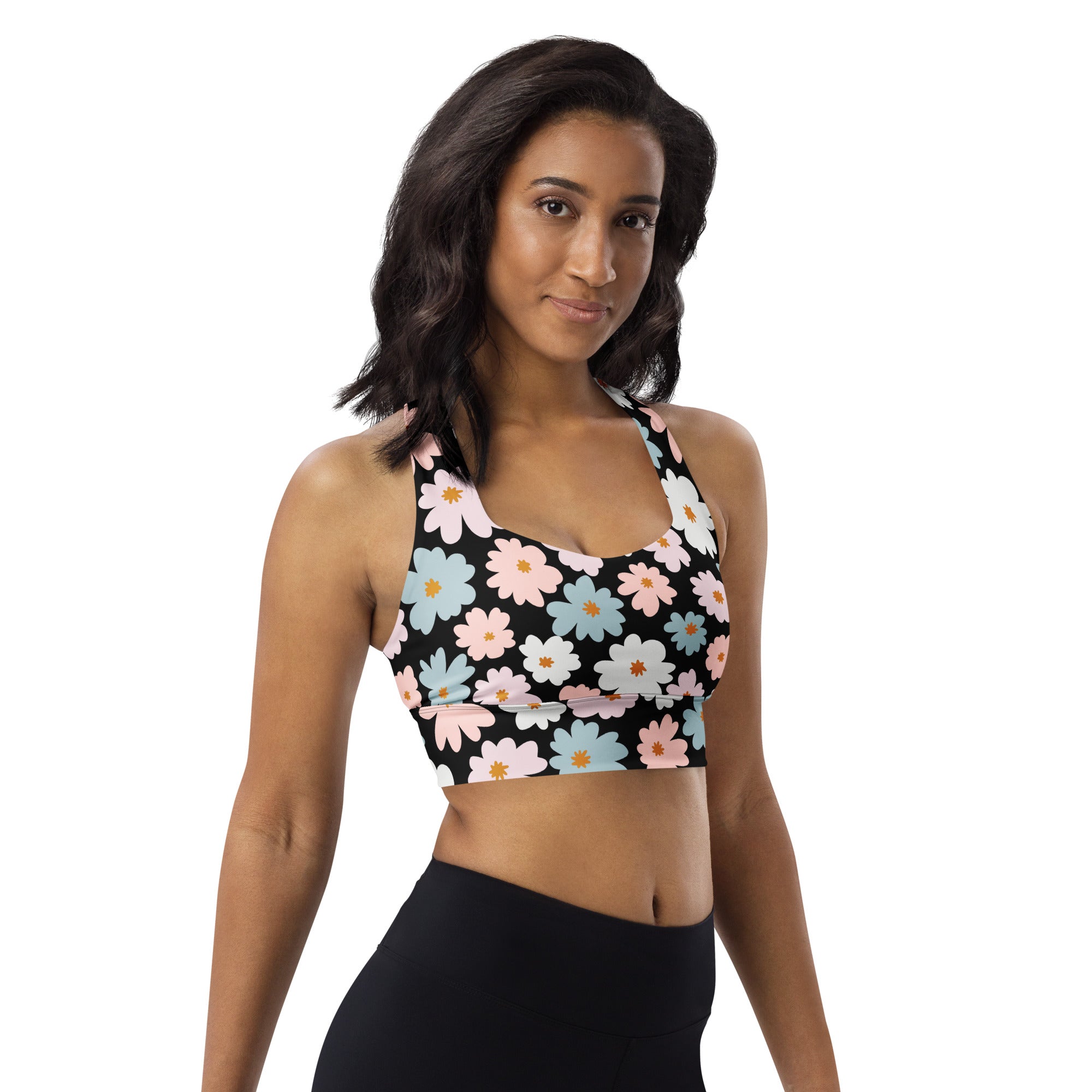 Black recycled longline sports bra with vibrant pink light blue and white daisies for high intensity support