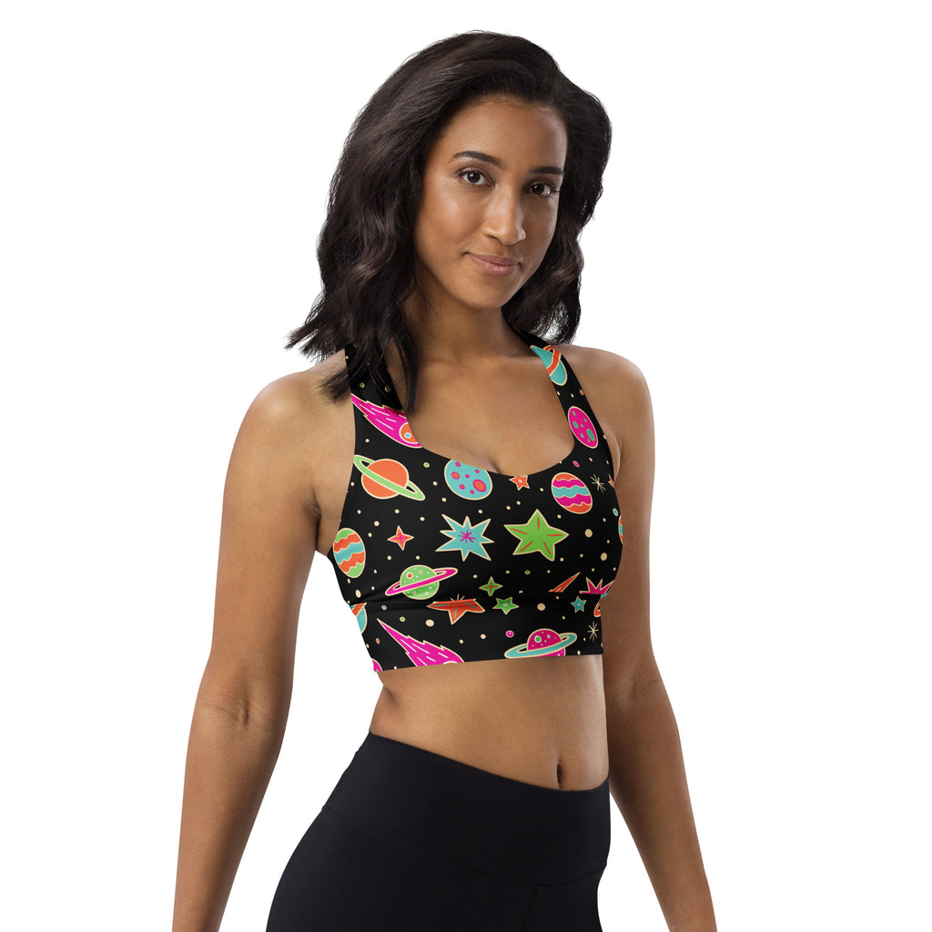 Women’s black recycled longline sports bra with cosmic neon pink green and blue planets stars and rockets pattern