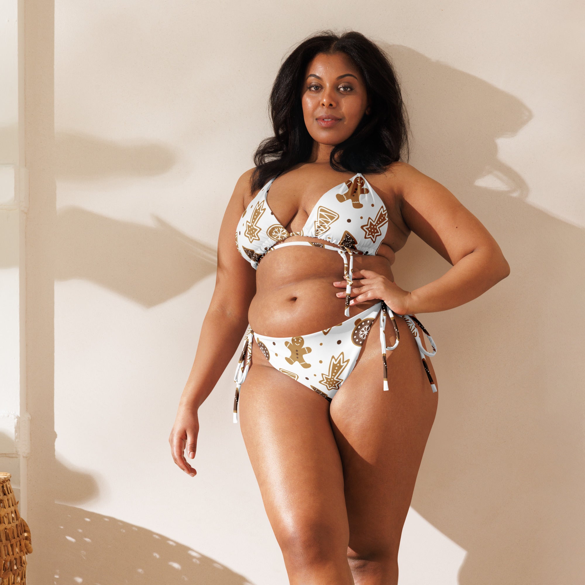 White bikini set with gold and brown gingerbread man and maple leaf patterns featuring adjustable ties and upf 50+ protection