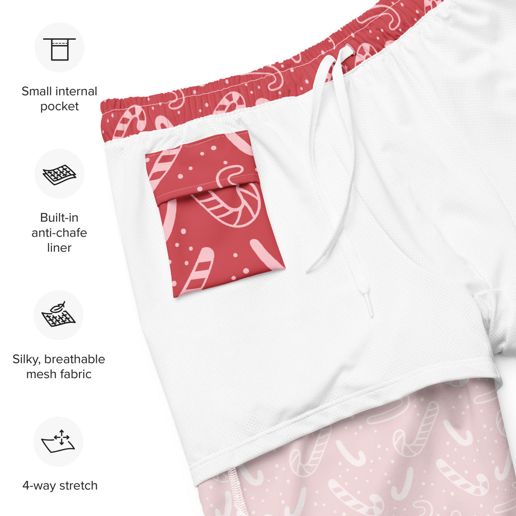 Men’s white swim trunks with red and pink candy cane patterned waistband, pocket, and lower leg designs