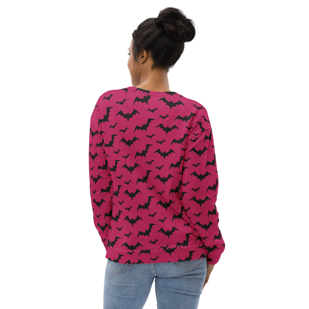 A vibrant pink long-sleeved sweatshirt with black bat pattern and brushed inner fleece fabric for Halloween