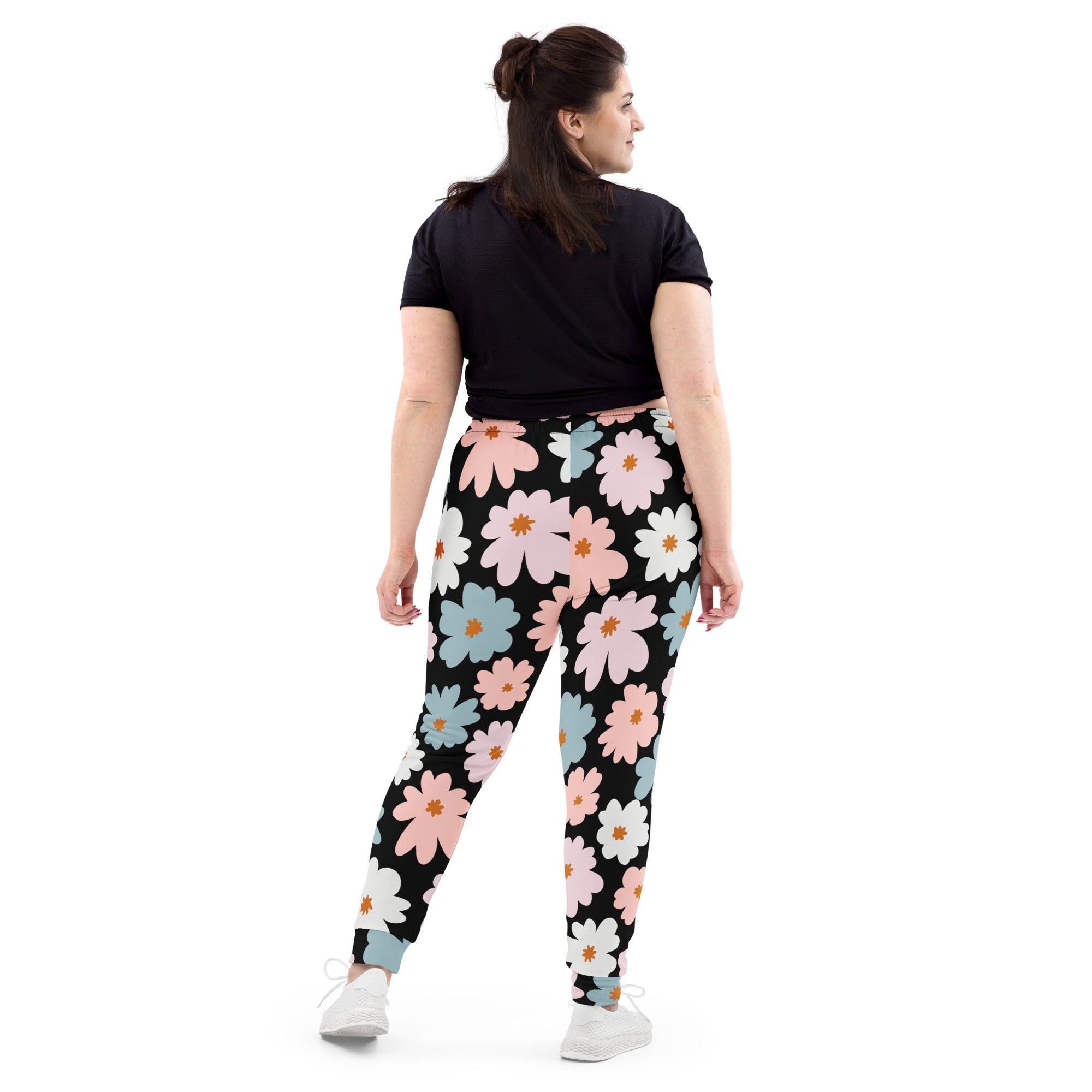 Women’s retro floral recycled jogger pants in black with vibrant pink white and blue daisy pattern and cozy fleece lining