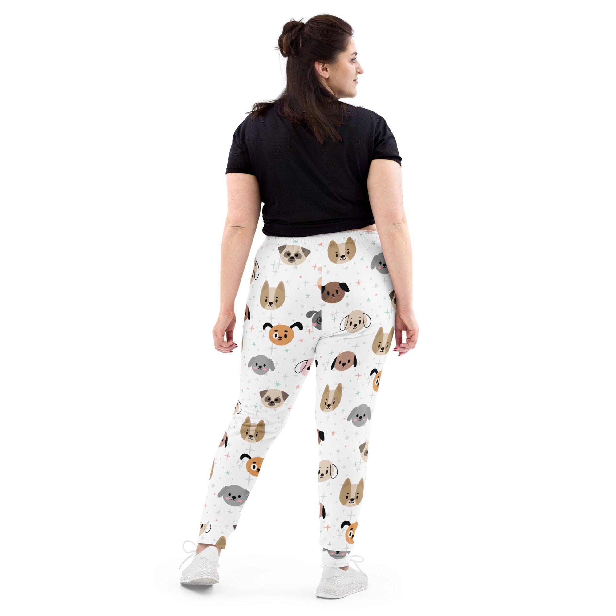 Women’s white recycled jogger pants with pockets featuring colorful cartoon dog faces and cozy brushed fleece inside