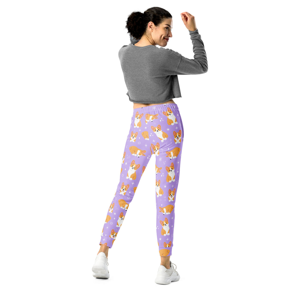 Women’s purple recycled jogger pants with pockets featuring a playful orange and white corgi pattern and cozy fleece inside