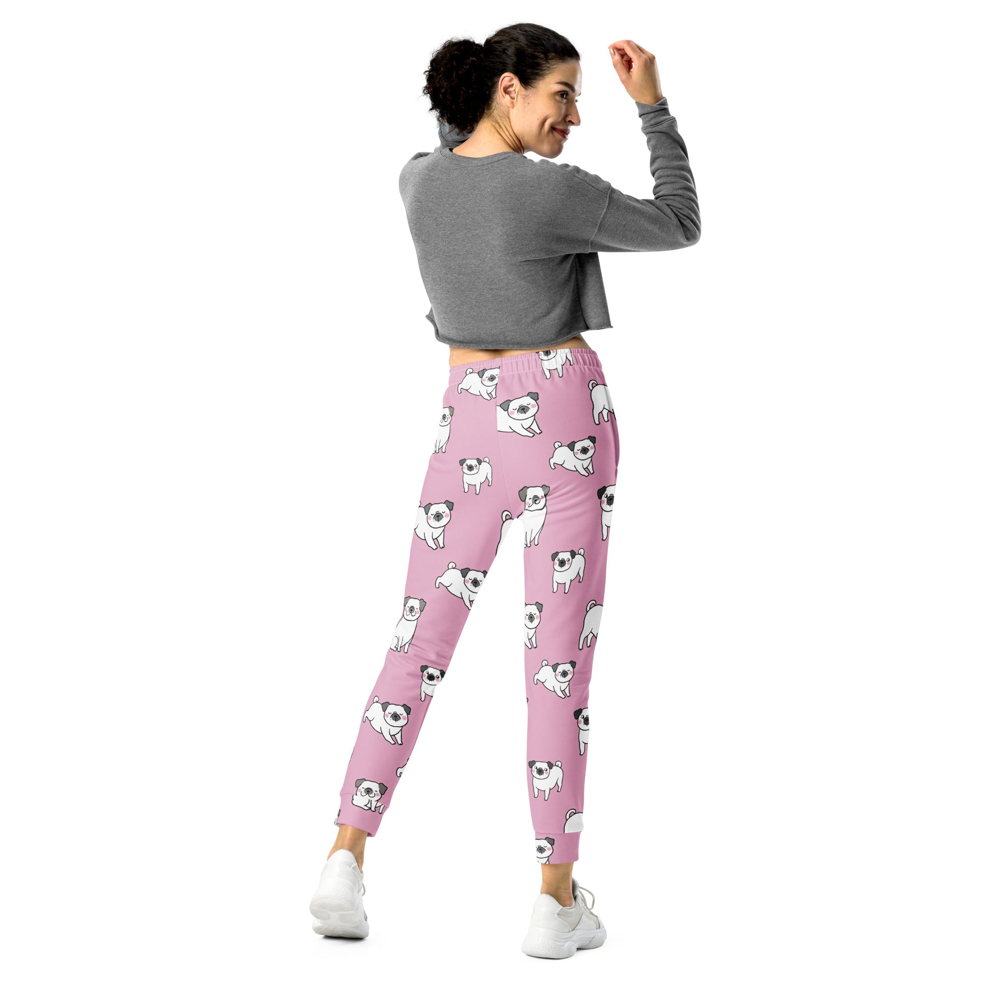 Women’s pink recycled jogger pants with cozy brushed fleece inside featuring playful white pug illustrations and pockets
