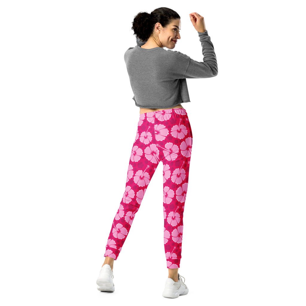 Women’s pink hibiscus floral recycled jogger pants with cozy brushed inside fleece and pockets shown from the front