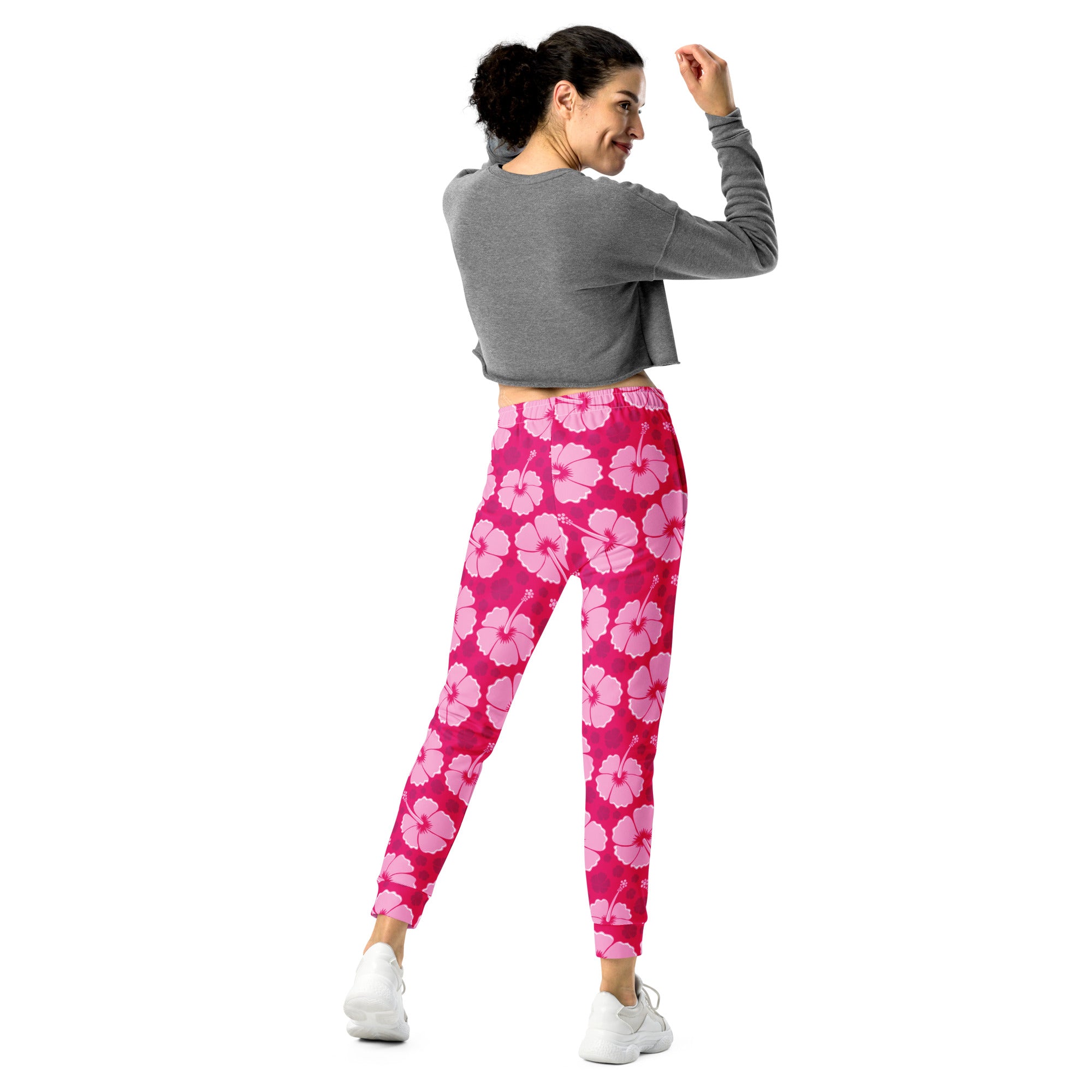 Women’s pink hibiscus floral recycled jogger pants with cozy brushed inside fleece and pockets shown from the front