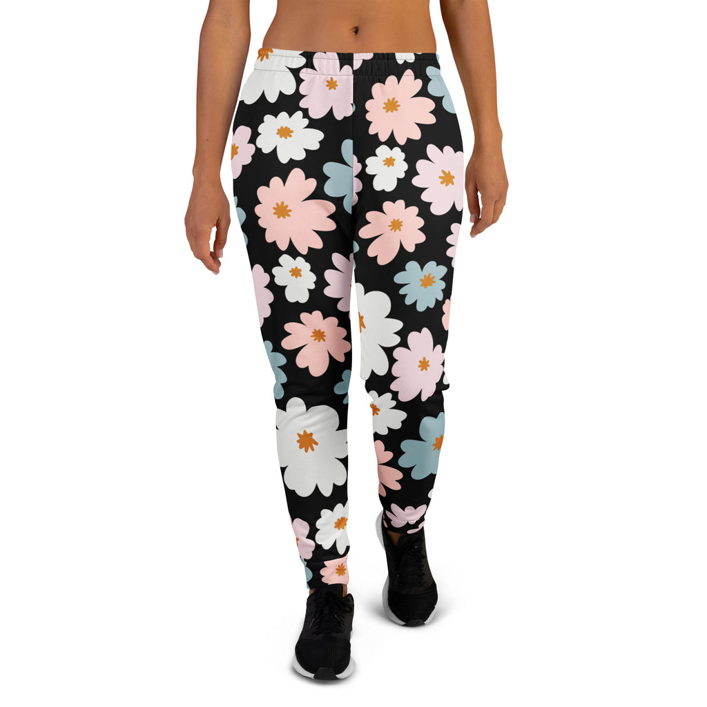 Women’s black recycled jogger pants with cozy brushed fleece featuring vibrant pink white and light blue daisy patterns