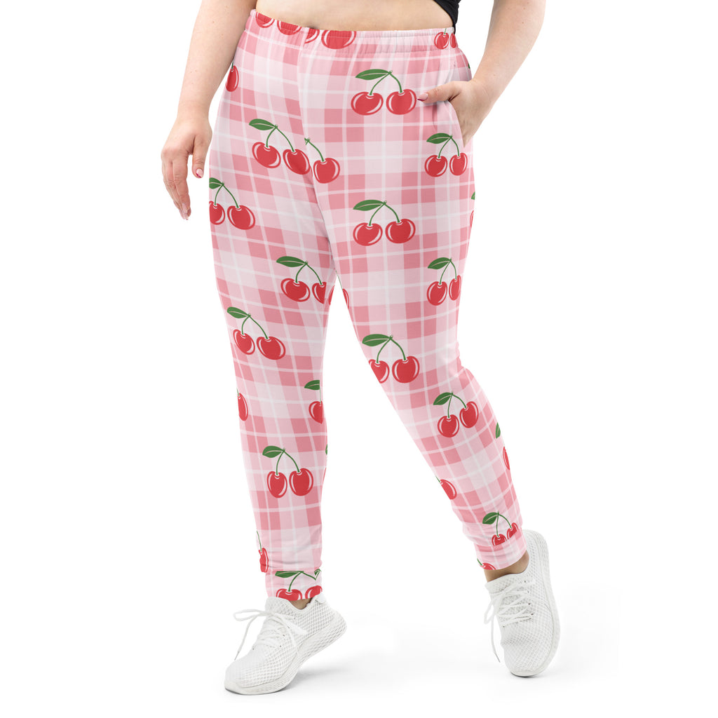 Women’s pink cherry plaid recycled jogger pants with pockets featuring red cherry pattern and cozy brushed fleece lining
