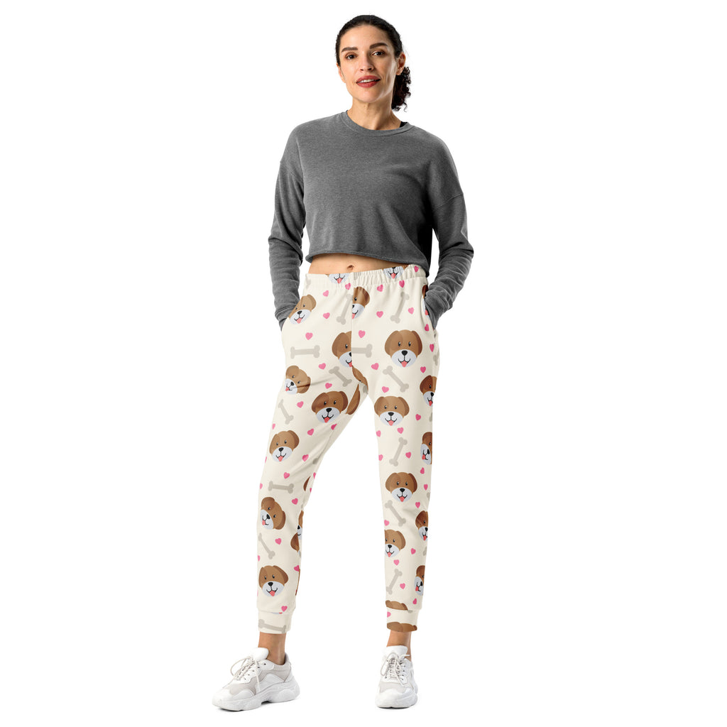 Cream-colored women’s jogger pants with brown puppy faces and pink hearts made from cozy recycled fleece with pockets