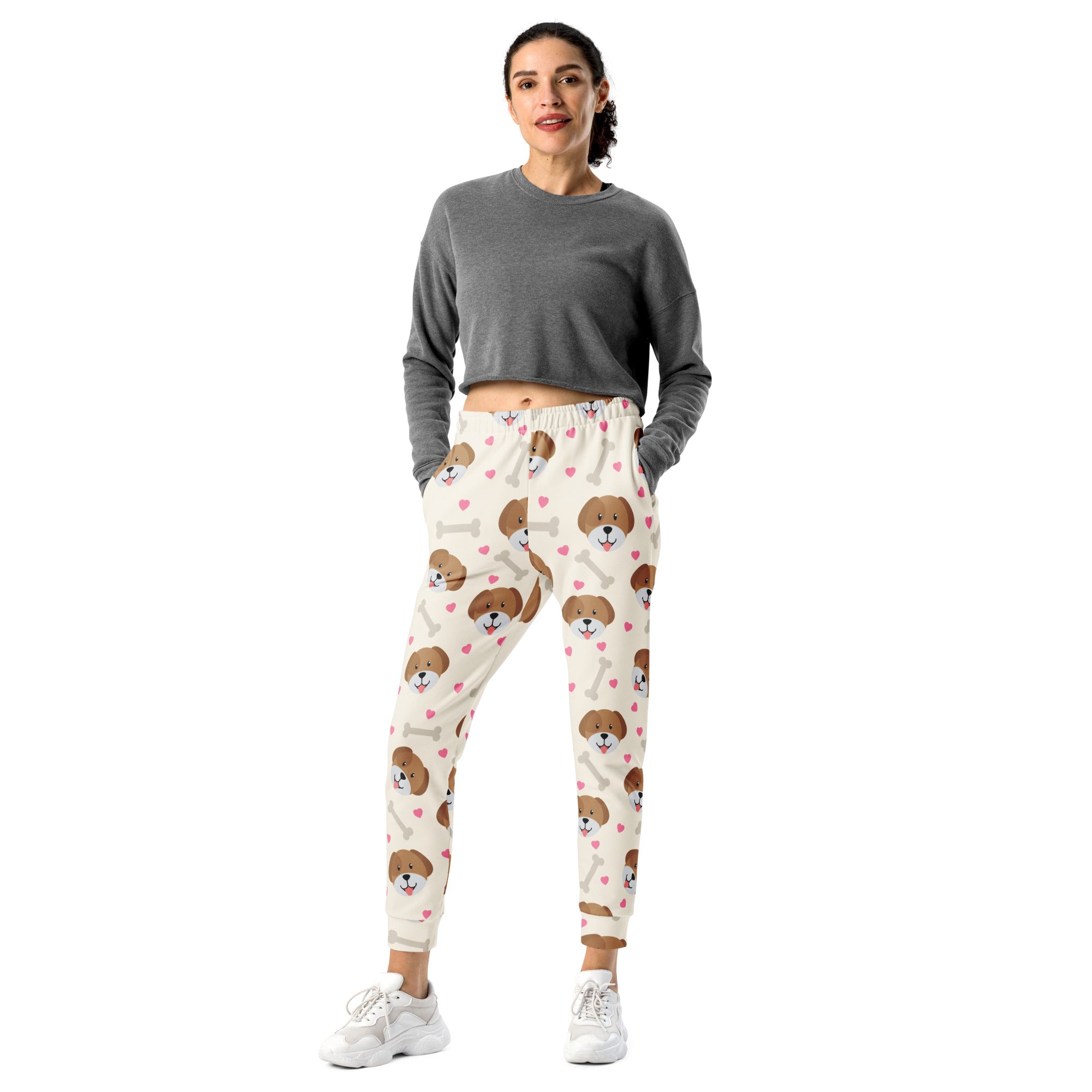 Cream-colored women’s jogger pants with brown puppy faces and pink hearts made from cozy recycled fleece with pockets