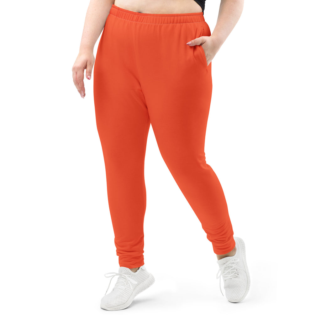 Women’s bright orange recycled jogger pants with soft fleece, elastic waistband, and side pockets for cozy wear