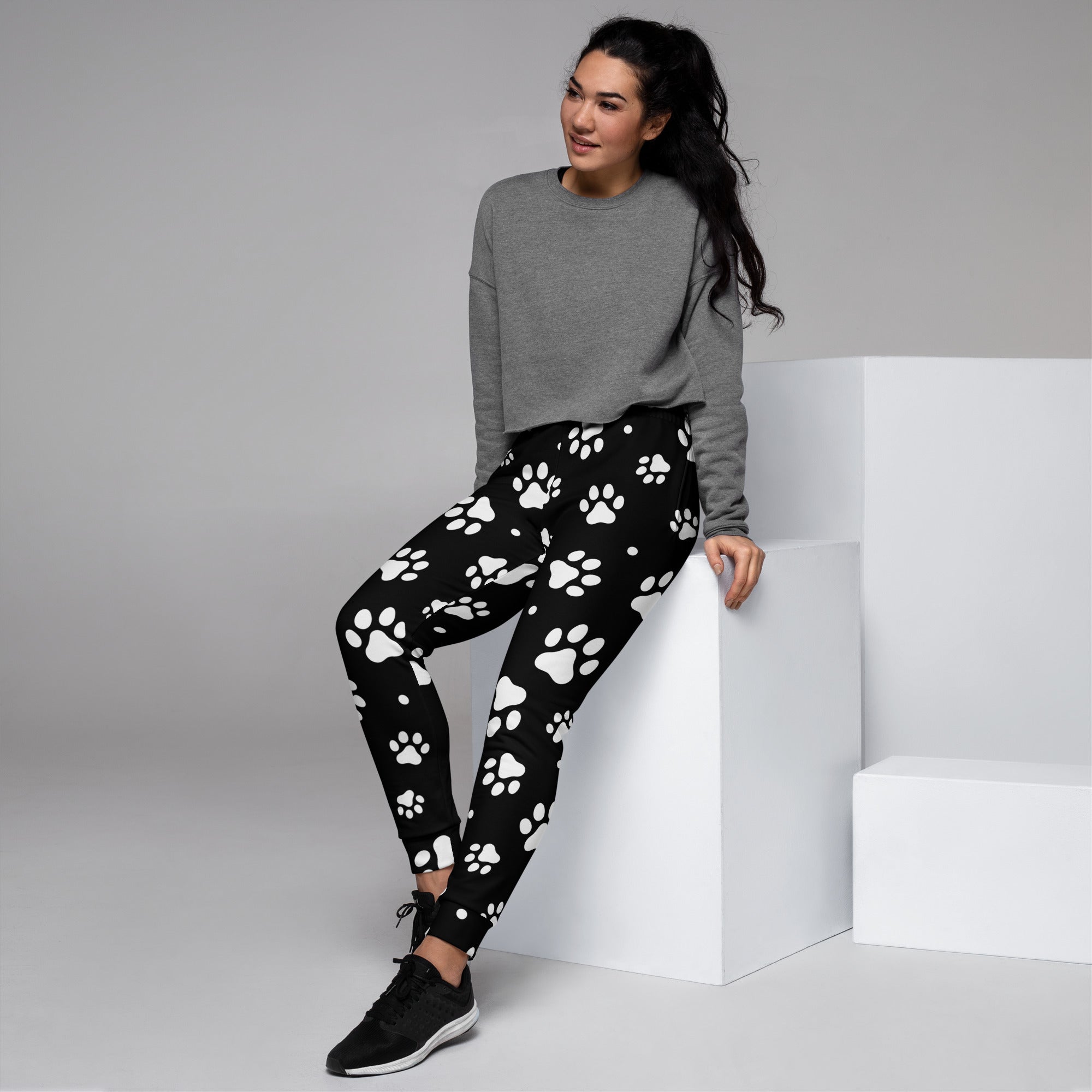Women’s black recycled jogger pants with white paw print pattern and cozy brushed inside fleece with pockets