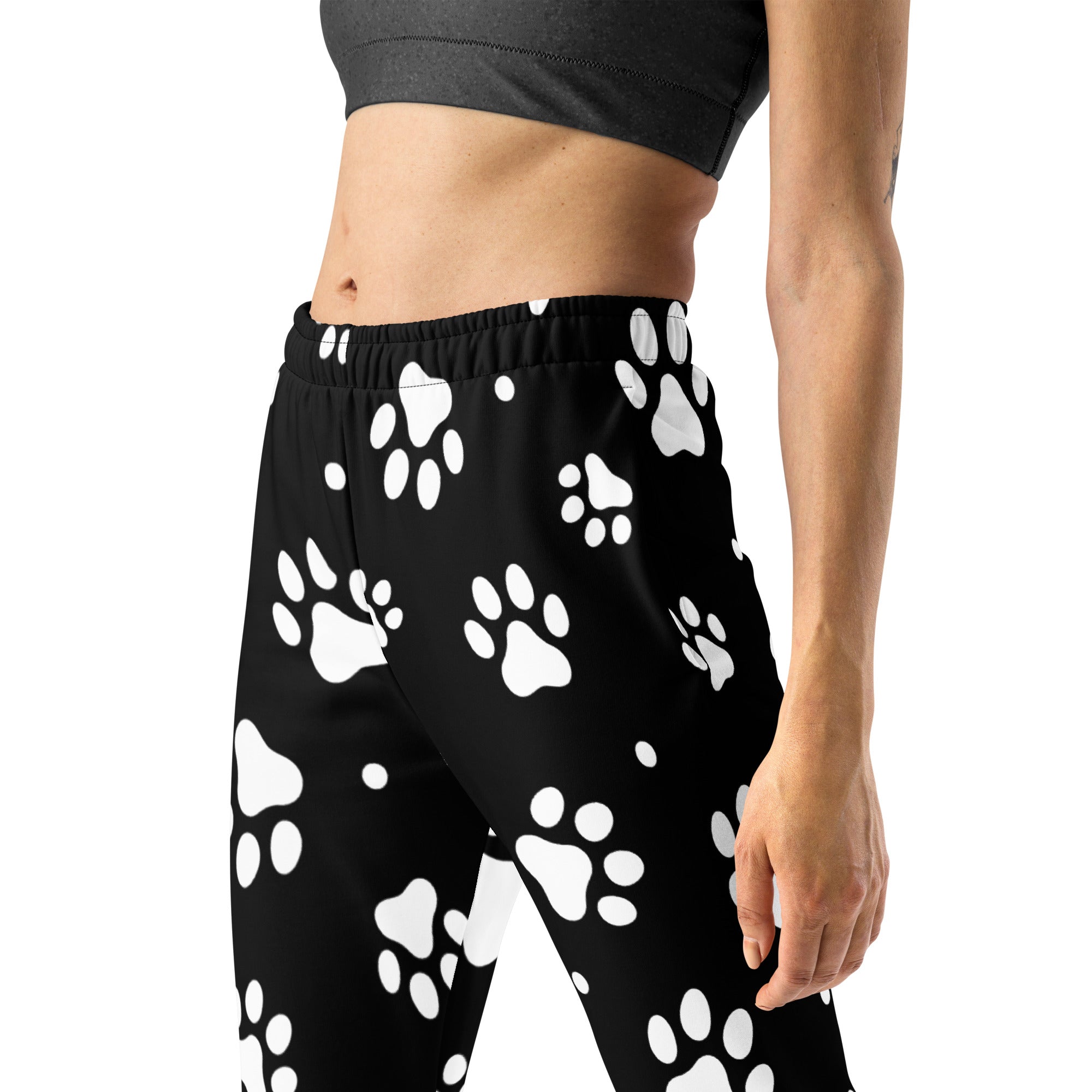 Women’s black recycled jogger pants with cozy brushed fleece inside featuring playful white paw print pattern and pockets