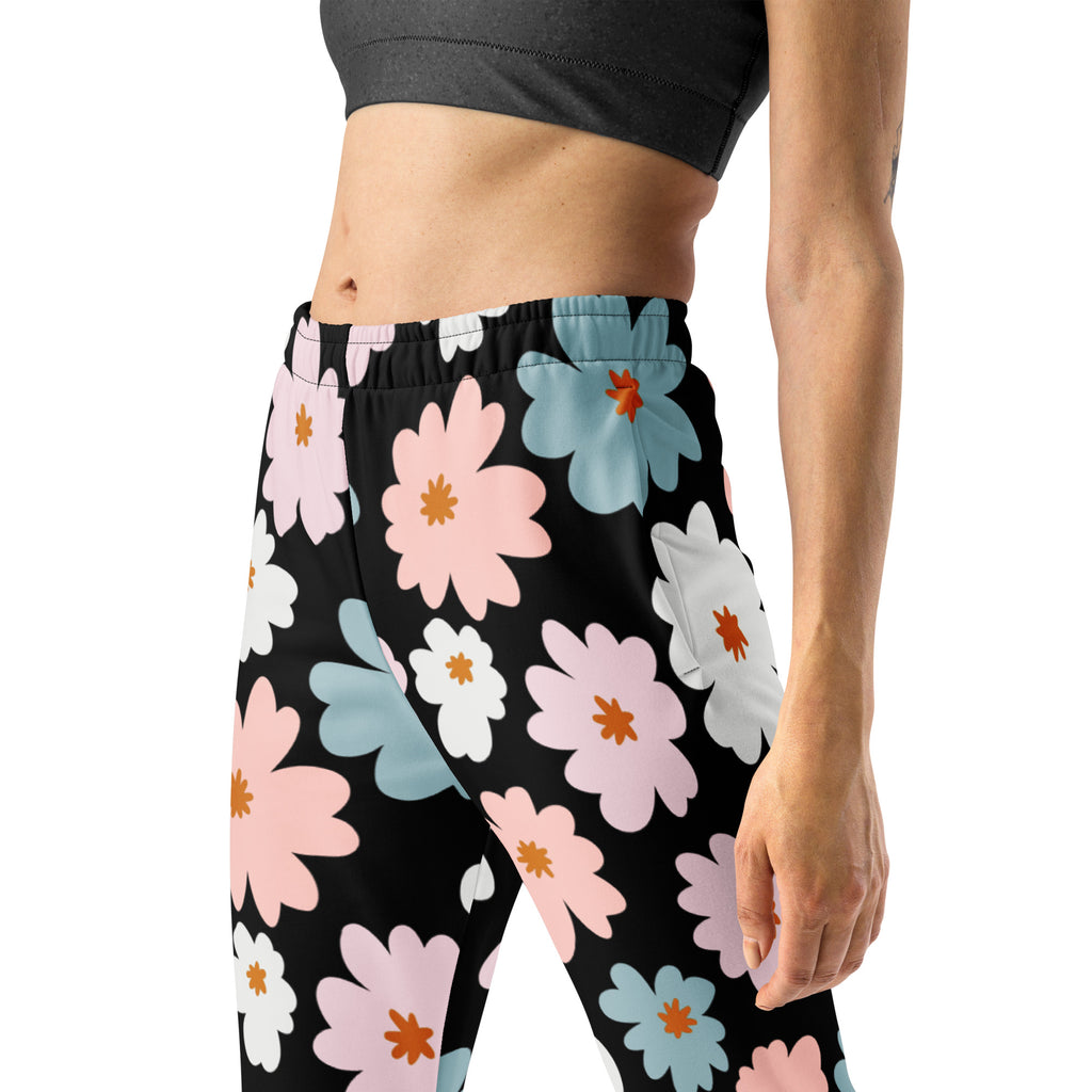 Women’s retro floral recycled jogger pants with pockets featuring black leggings with vibrant pink white and blue flowers