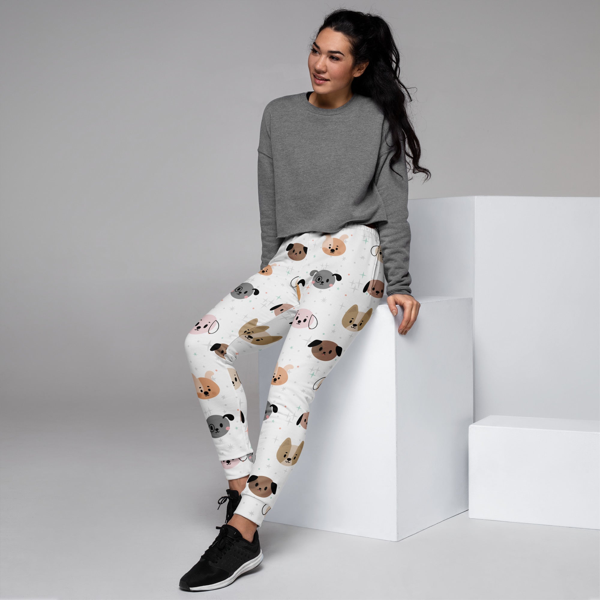 Women’s white recycled jogger pants with cozy fleece inside featuring playful cartoon dogs in brown gray and tan hues