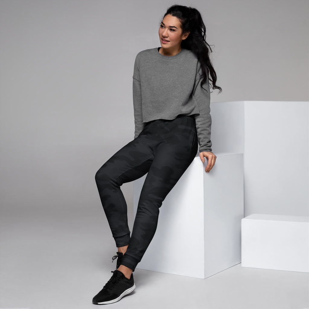 Gray long-sleeved sweatshirt with relaxed fit and ribbed cuffs paired with women’s black camouflage recycled jogger pants with pockets
