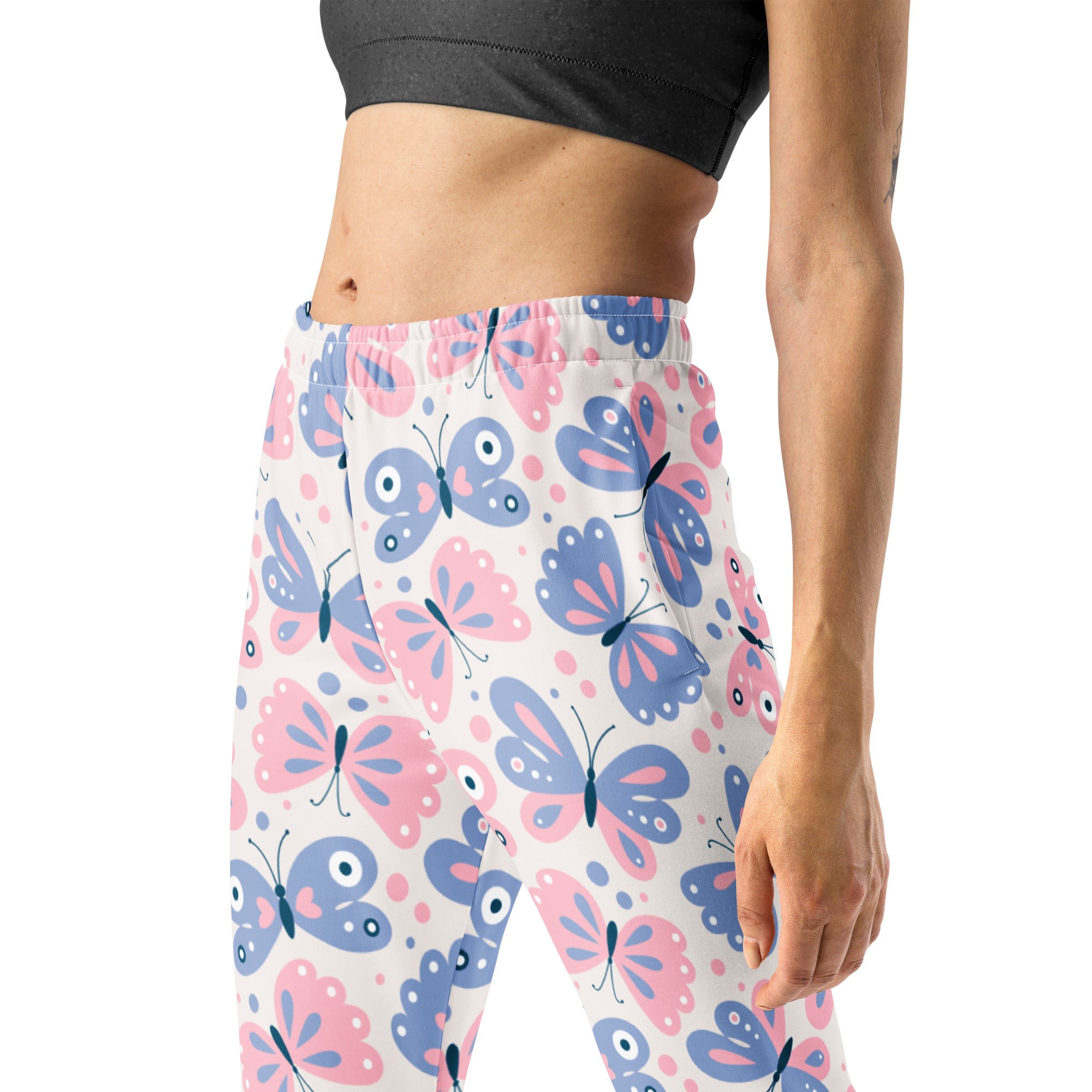Women’s butterfly recycled jogger pants with pockets featuring pink and blue butterfly leggings on a white base