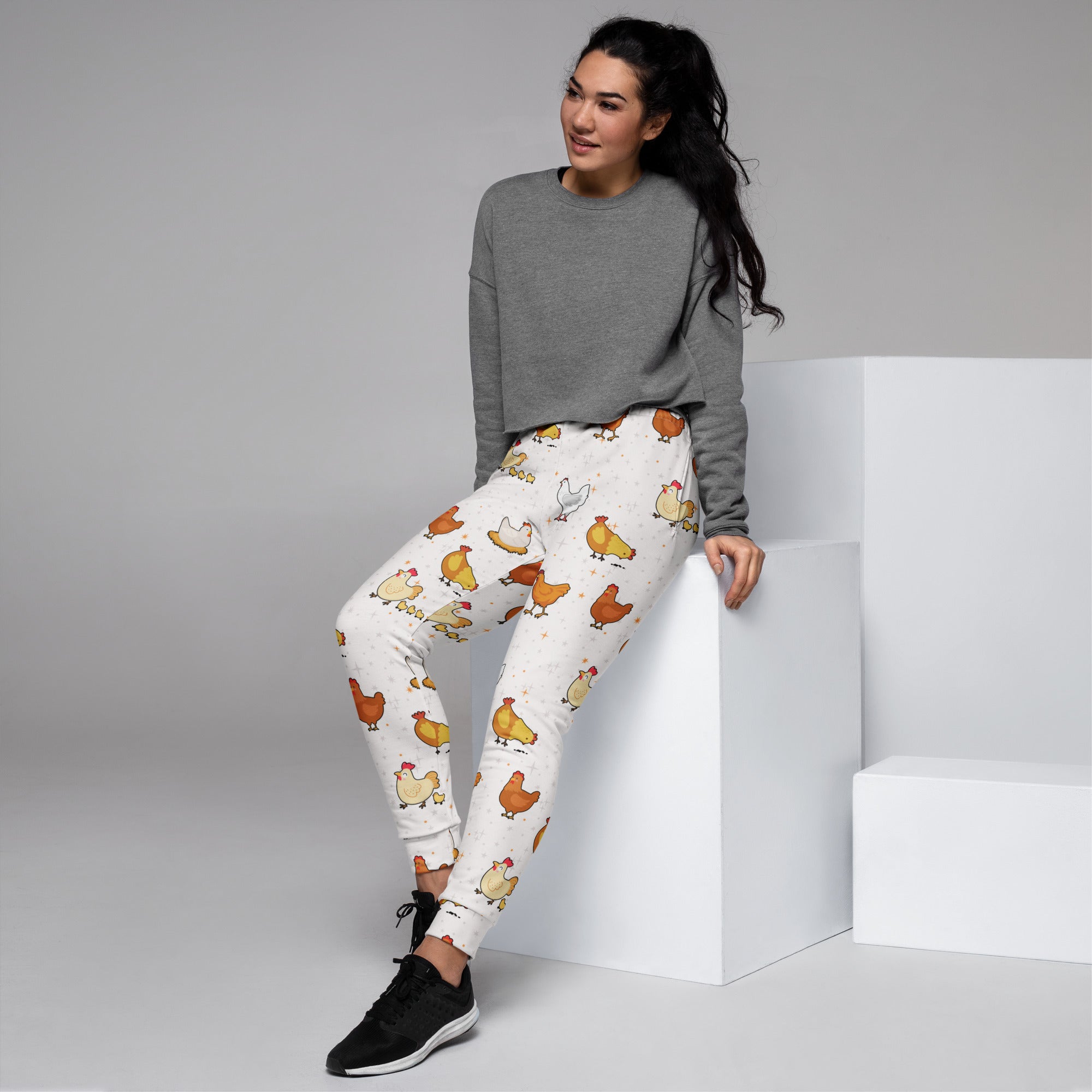 Women’s white recycled jogger pants with cozy fleece inside and playful brown yellow cartoon chicken pattern