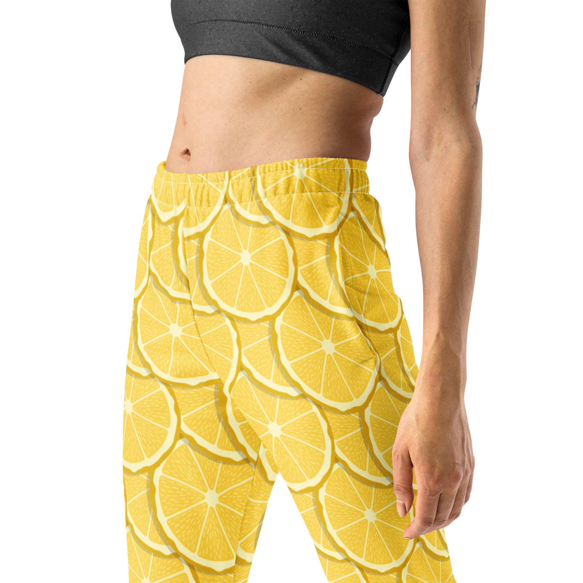 Bright yellow women’s jogger pants with sliced lemon pattern made from recycled cozy brushed fleece with pockets