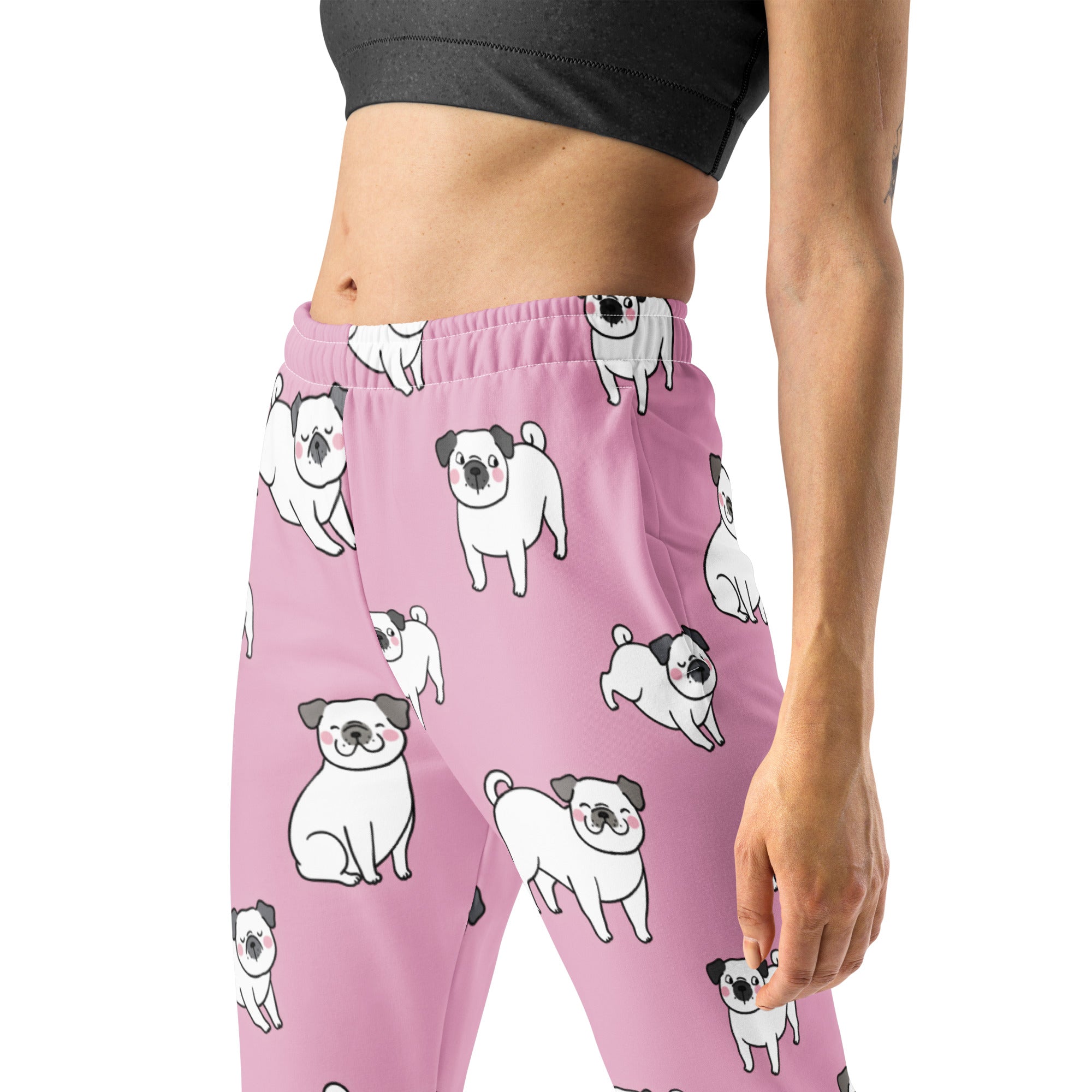 Women’s pink recycled jogger pants with pockets featuring a playful white pug pattern and cozy brushed fleece inside
