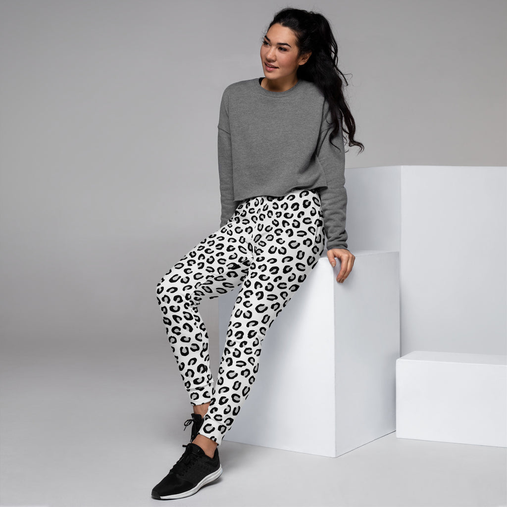 A pair of white leggings with a bold black leopard print made from recycled cozy brushed fleece