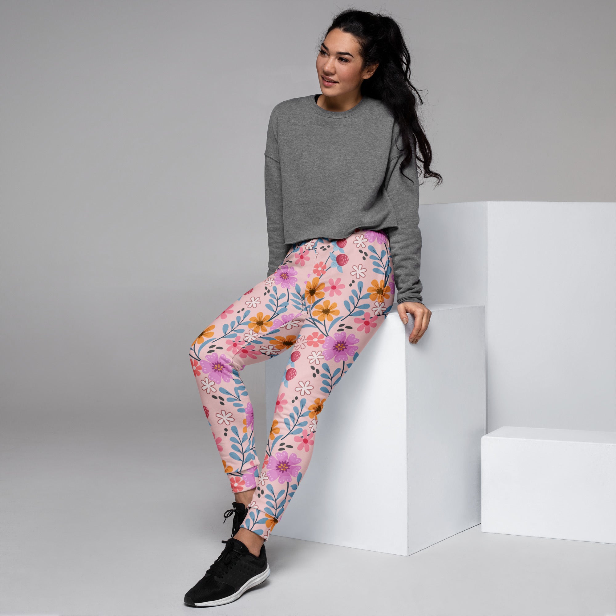 Women’s pink floral recycled jogger pants with pockets featuring soft stretchy fabric and vibrant purple orange blue blossoms