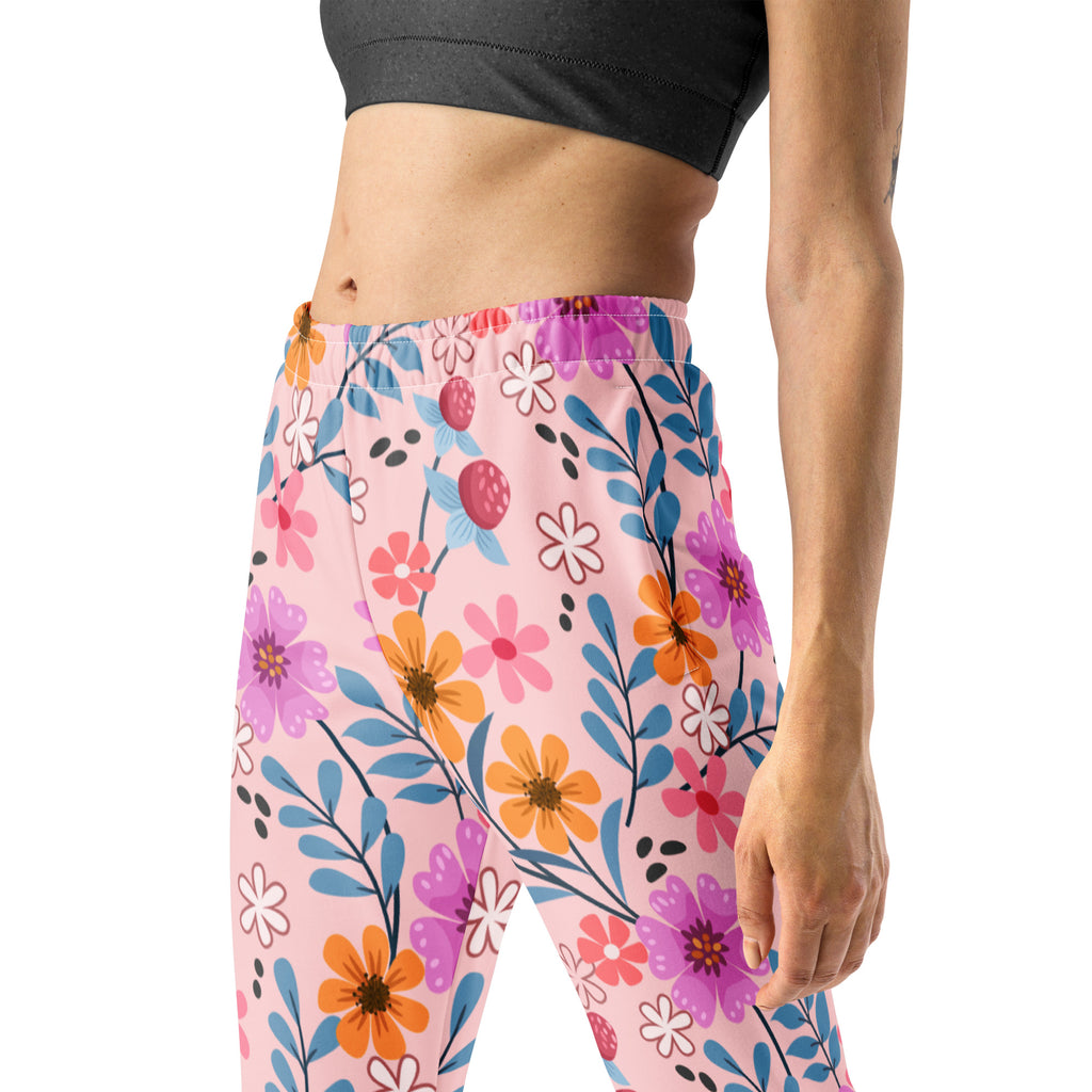 Women’s pink floral recycled jogger pants with pockets featuring a vibrant purple orange and blue flower pattern