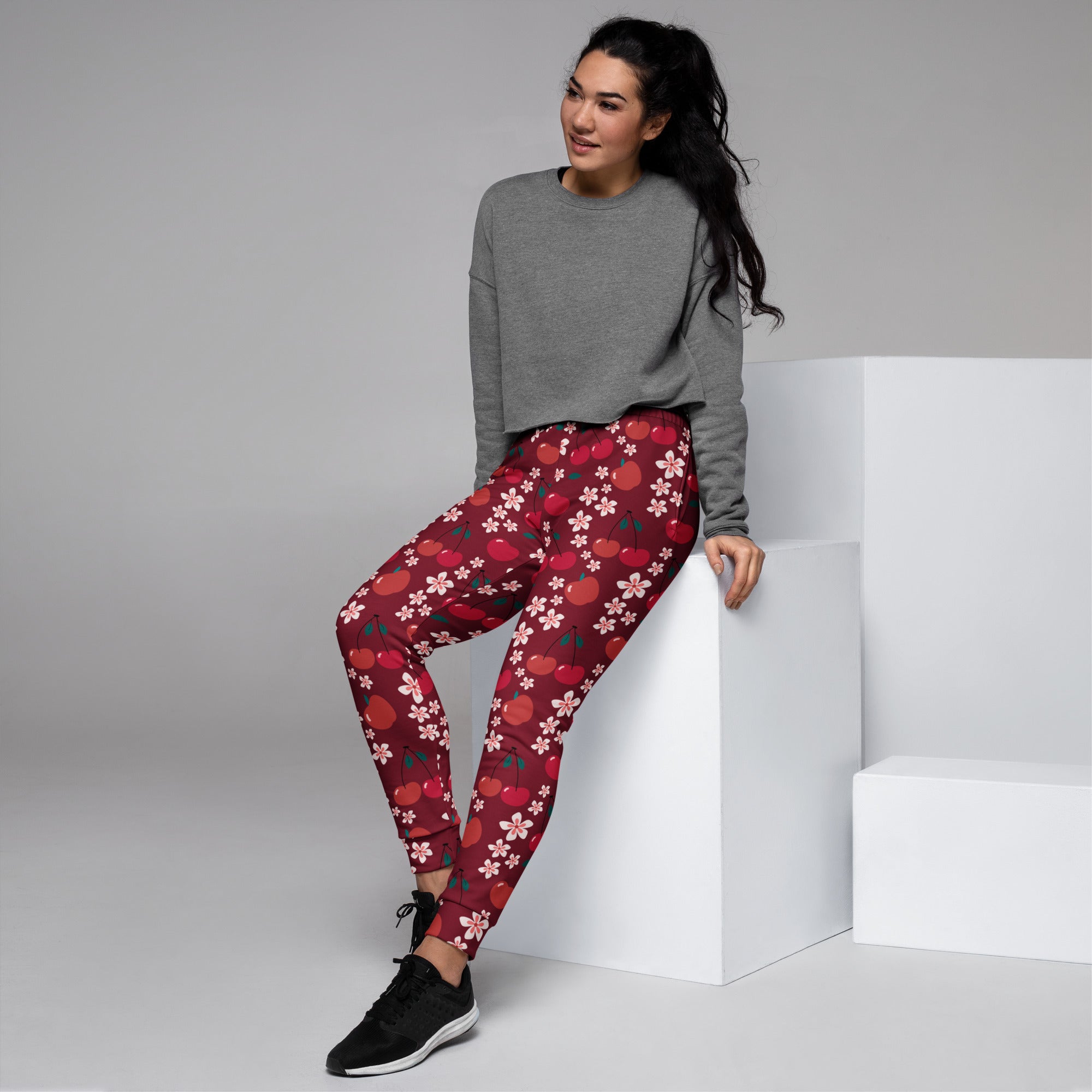 Red women’s cherry blossom recycled jogger pants with pockets featuring apple pattern and cozy brushed fleece interior