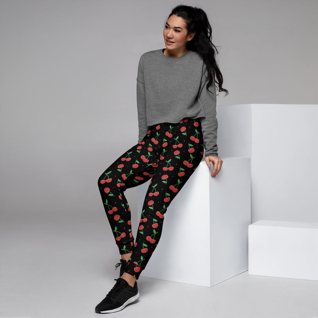 Women’s black cherry recycled jogger pants with pockets feature vibrant red cherry pattern and cozy brushed fleece inside