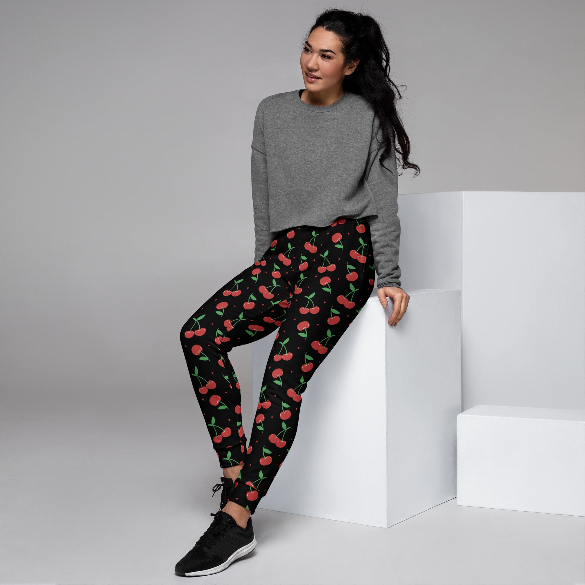 Women’s black cherry recycled jogger pants with pockets feature vibrant red cherry pattern and cozy brushed fleece inside