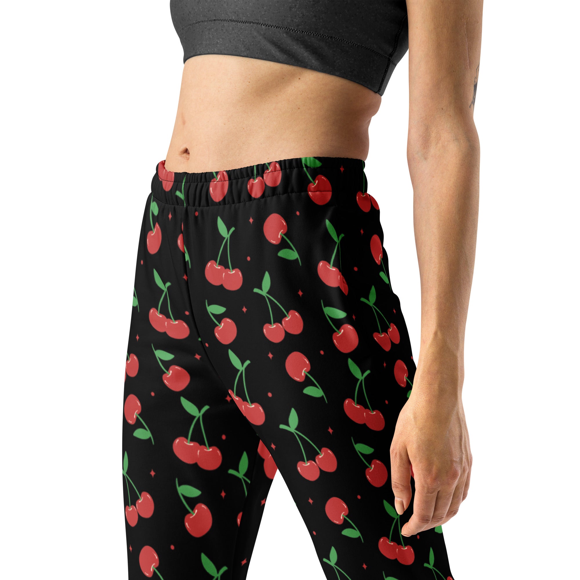 Women’s black cherry recycled jogger pants with vibrant red cherry pattern and cozy brushed inside fleece pockets