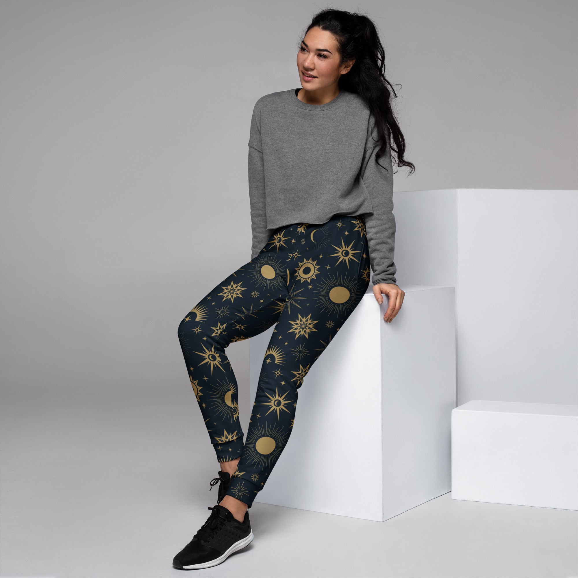 Dark blue women’s jogger pants with gold celestial sun moon star pattern made of recycled cozy fleece with pockets