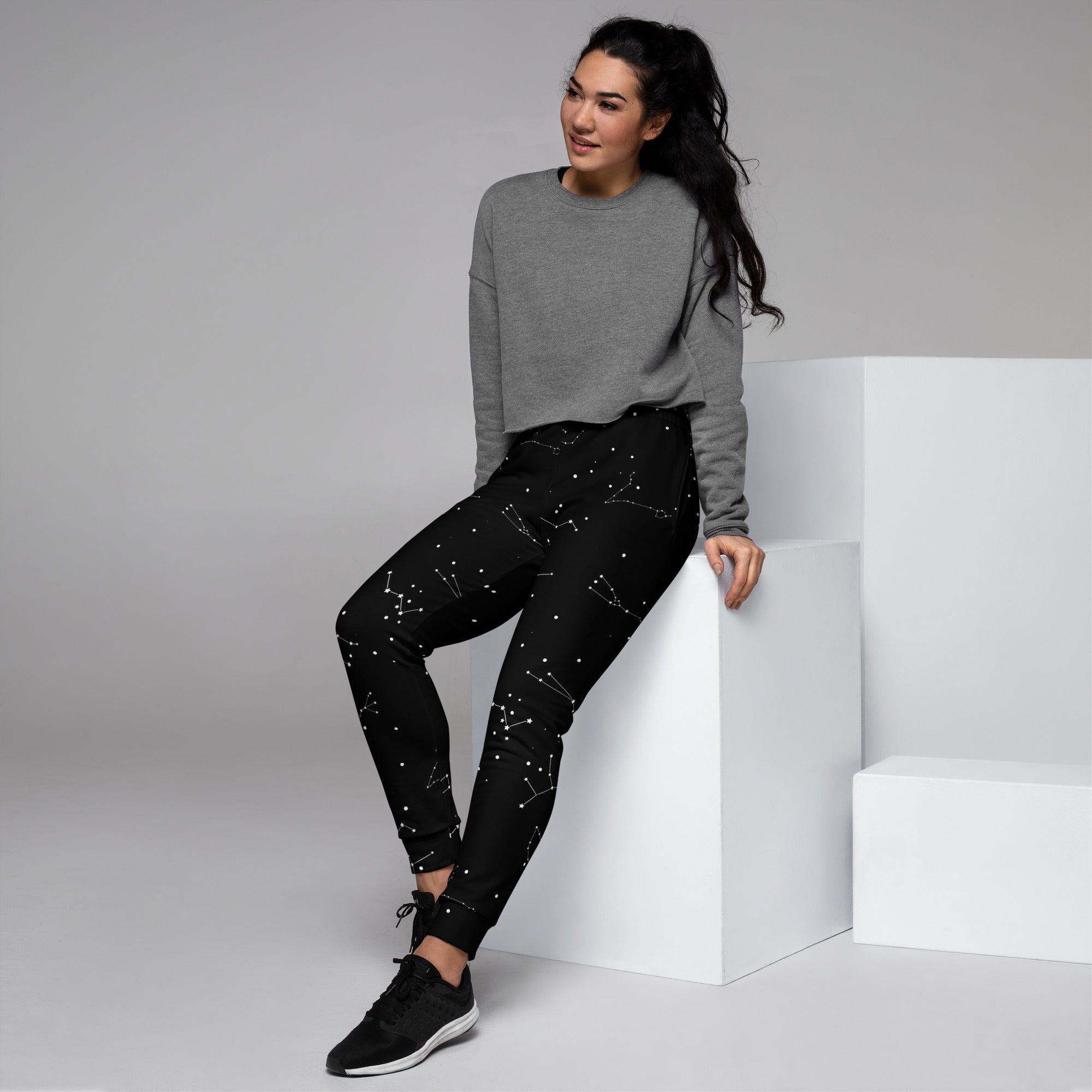Women’s black recycled jogger pants with cozy fleece inside featuring subtle white constellation pattern and pockets