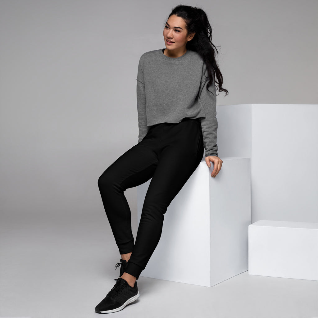 Gray long-sleeved sweatshirt with relaxed fit and ribbed cuffs paired with women’s black recycled jogger pants with fleece lining