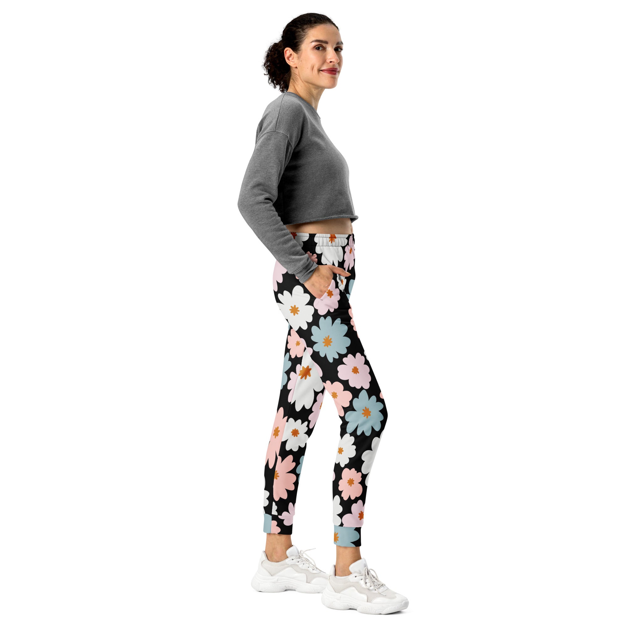 Women’s retro floral recycled jogger pants in black with vibrant white pink and blue daisy print and cozy fleece lining