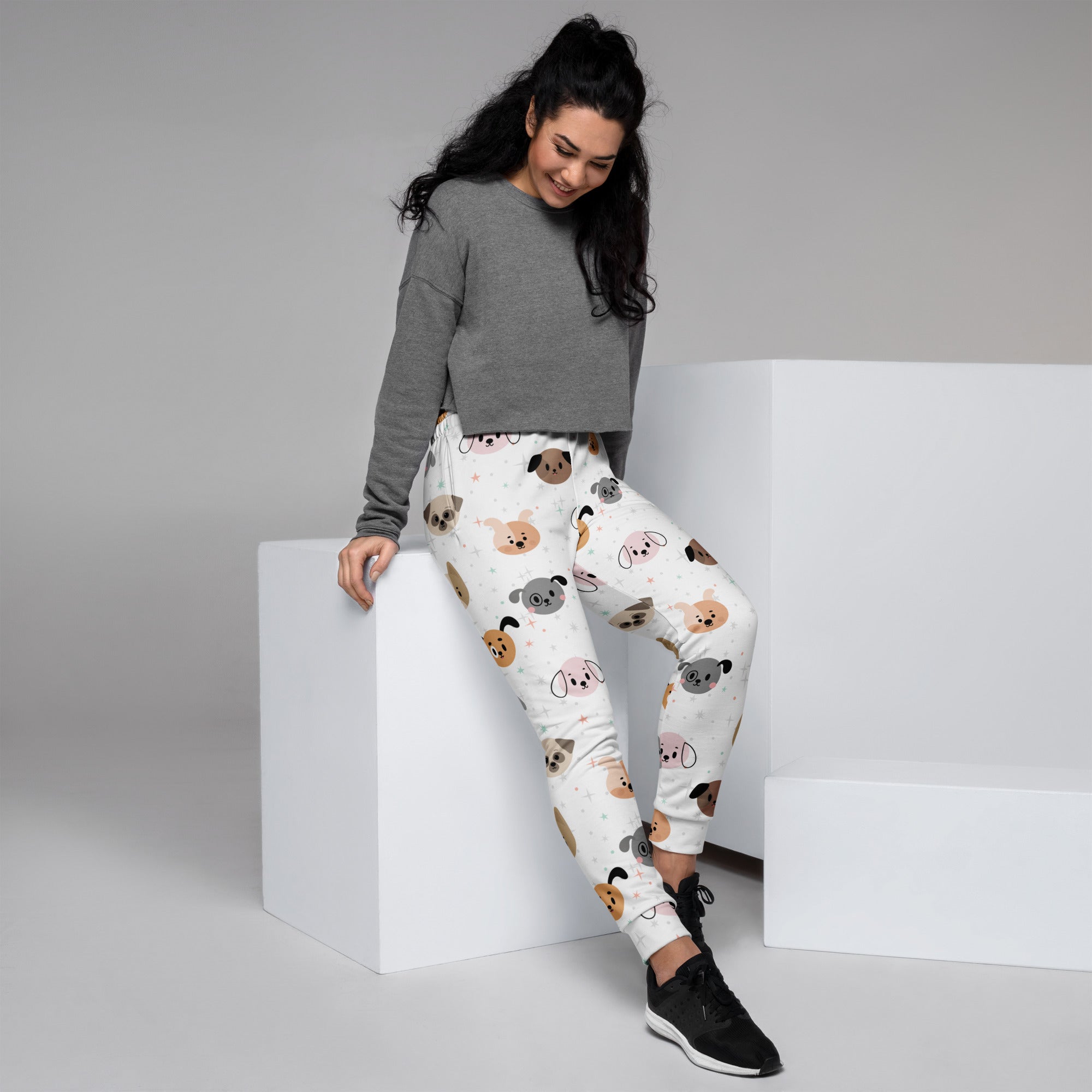 Women’s white recycled jogger pants with cozy brushed fleece inside featuring colorful cartoon dog faces and pockets