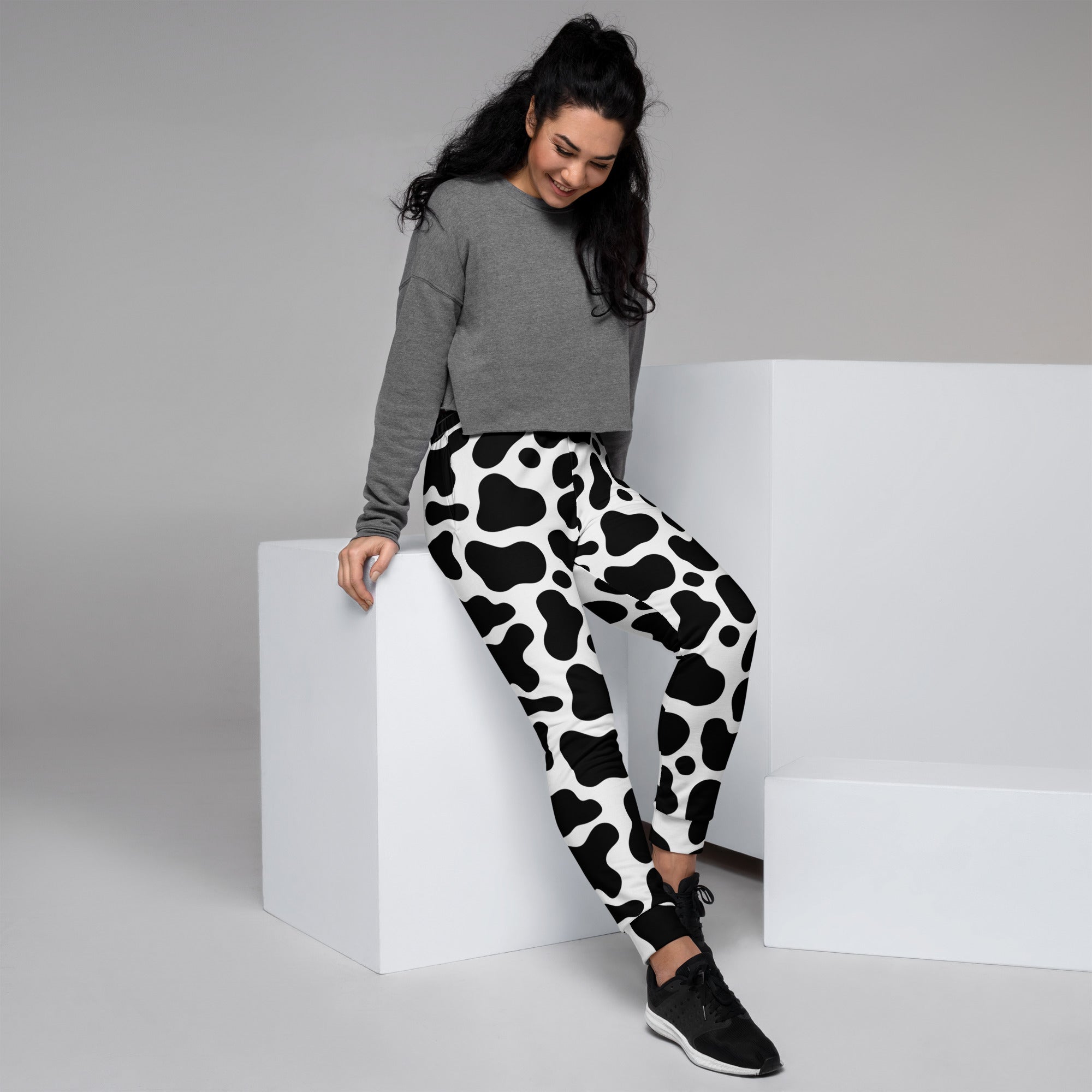 Women’s black and white cow print recycled jogger pants with pockets and cozy brushed inside fleece material