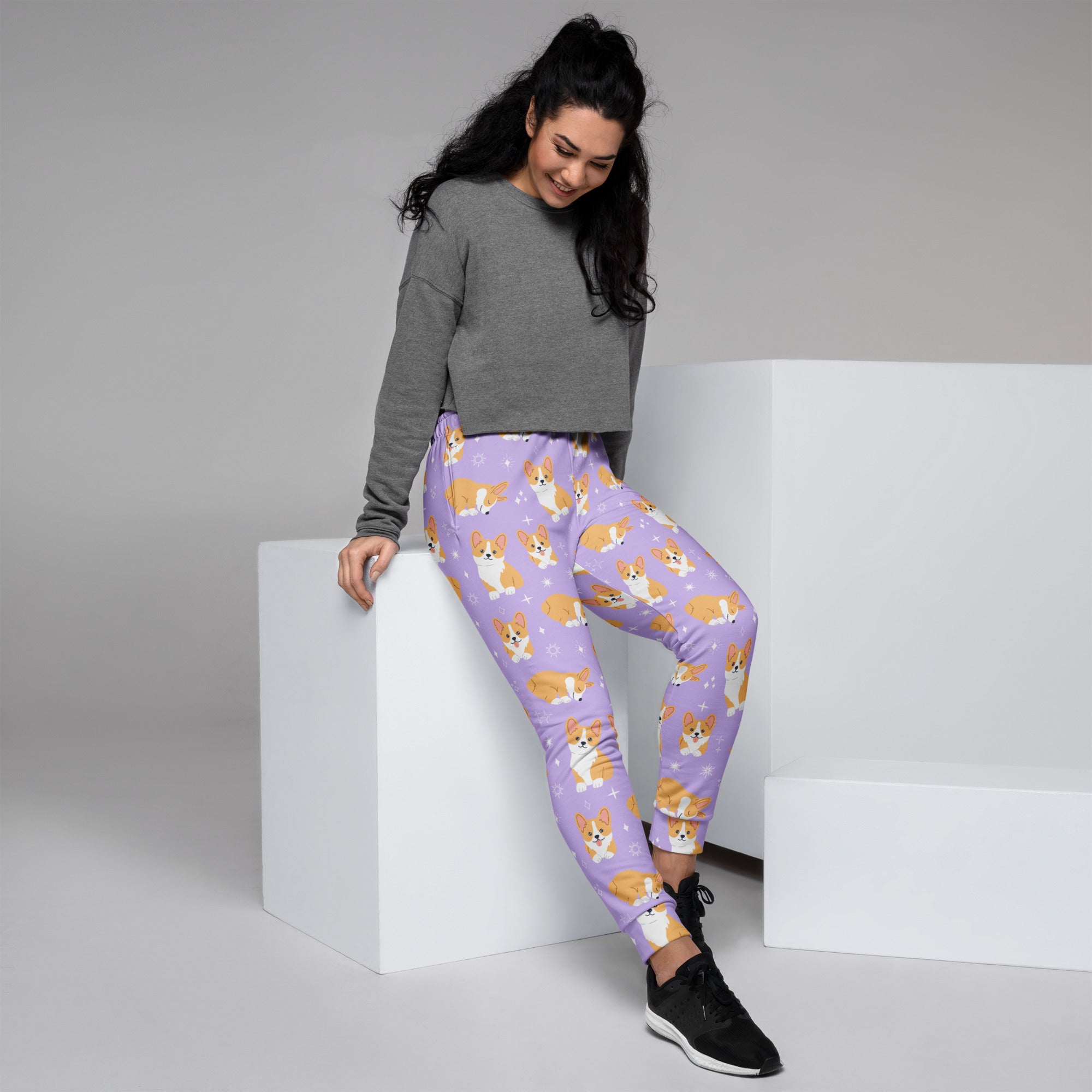 Women’s purple recycled jogger pants with cozy fleece inside featuring tan and white cartoon corgis with pockets