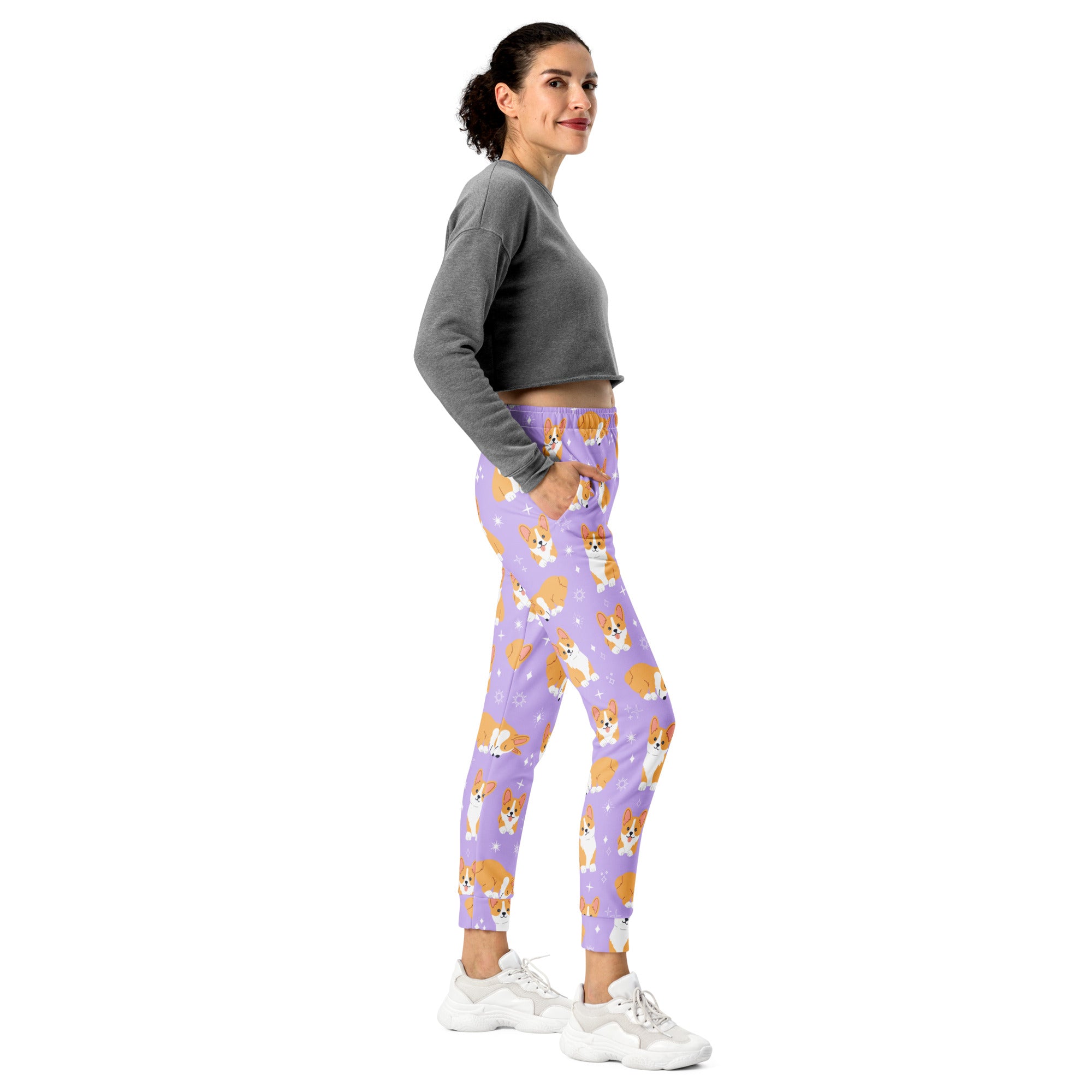 Women’s purple recycled jogger pants with cozy brushed fleece inside featuring playful orange and white corgi pattern