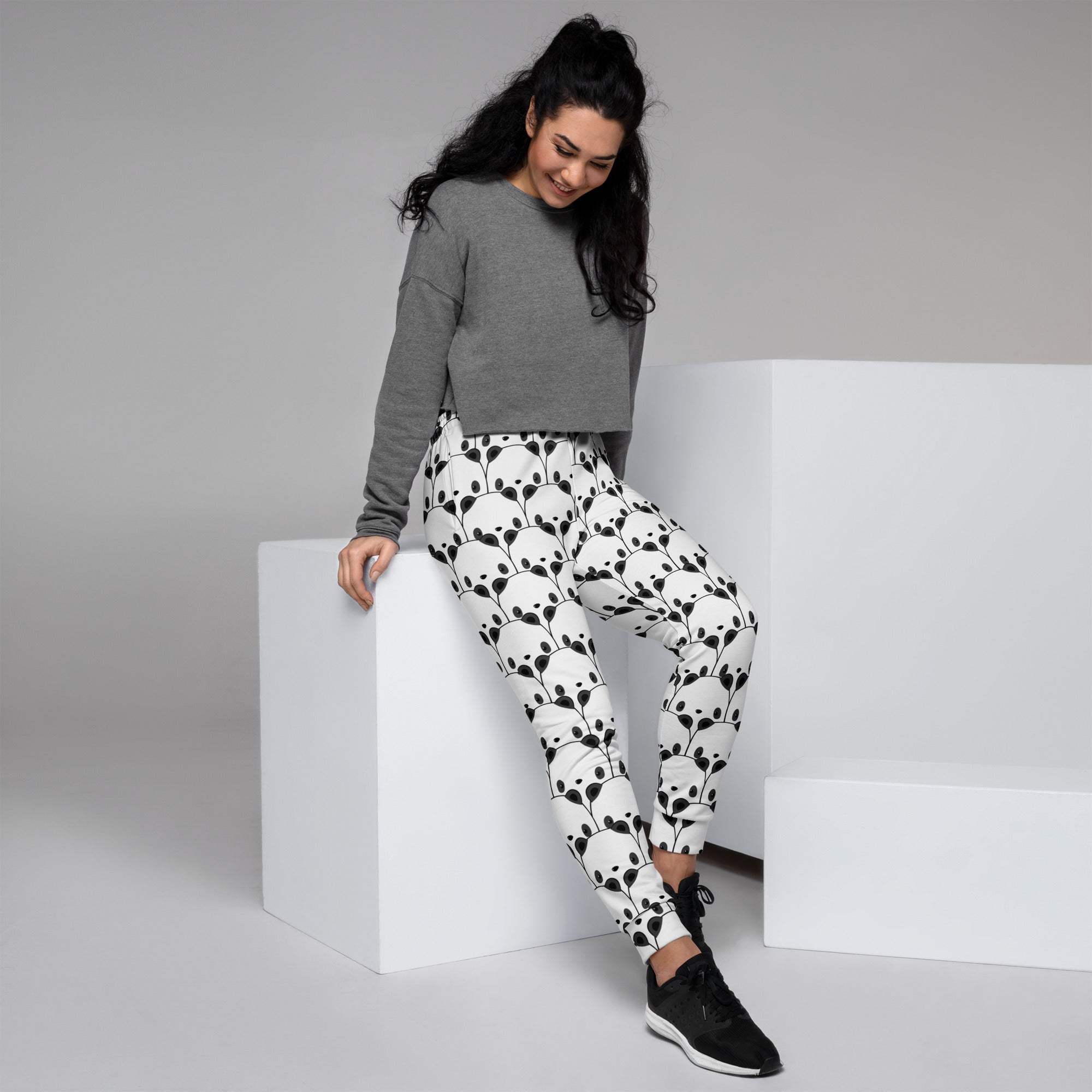 White women’s jogger pants with black panda face pattern made from cozy recycled fleece with pockets