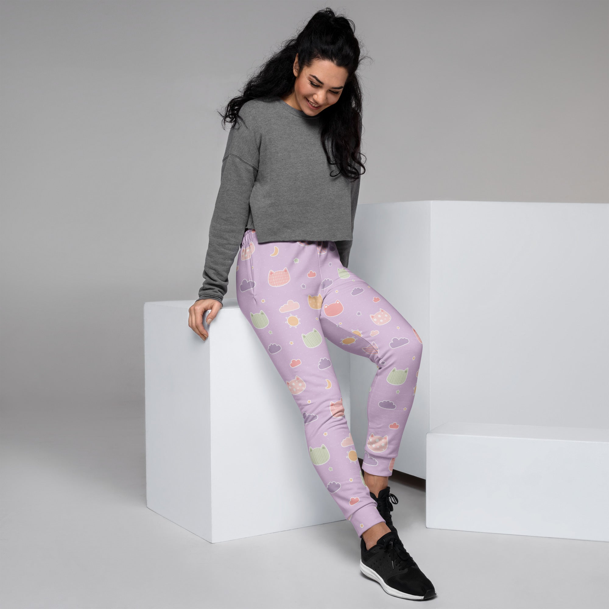 Women’s pastel purple jogger pants with playful cat faces and hearts pattern made from cozy recycled fleece