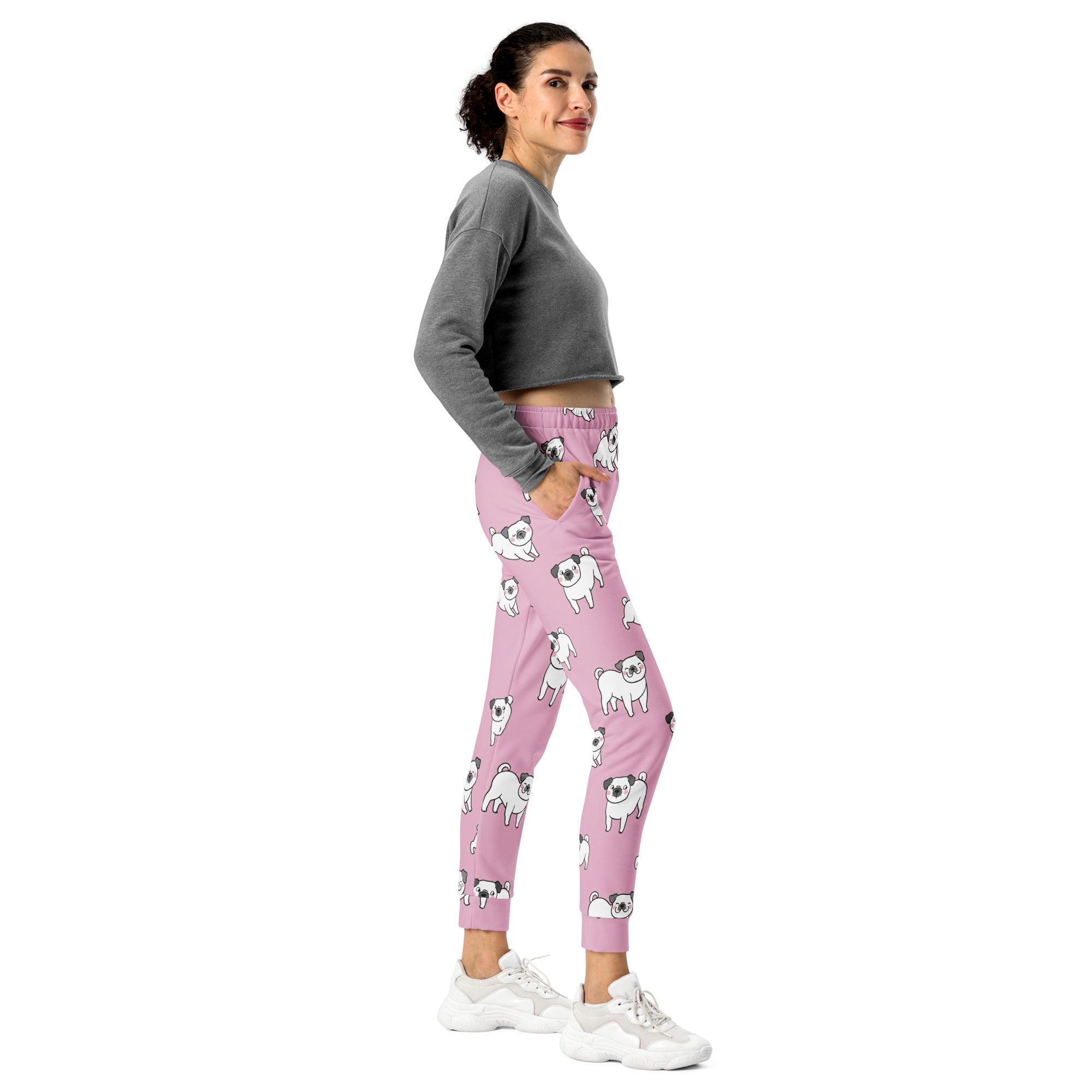 Women’s pink recycled jogger pants with pockets featuring playful white pug illustrations and cozy brushed fleece inside