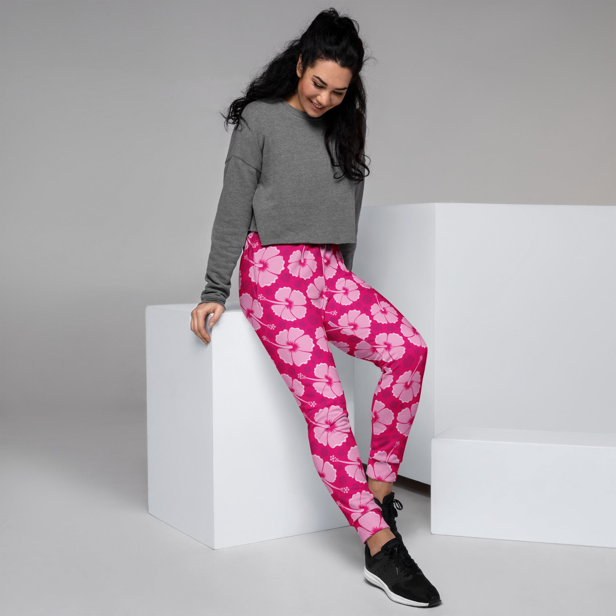 Women’s pink hibiscus floral recycled jogger pants with pockets made of soft stretchy fabric and cozy brushed fleece inside