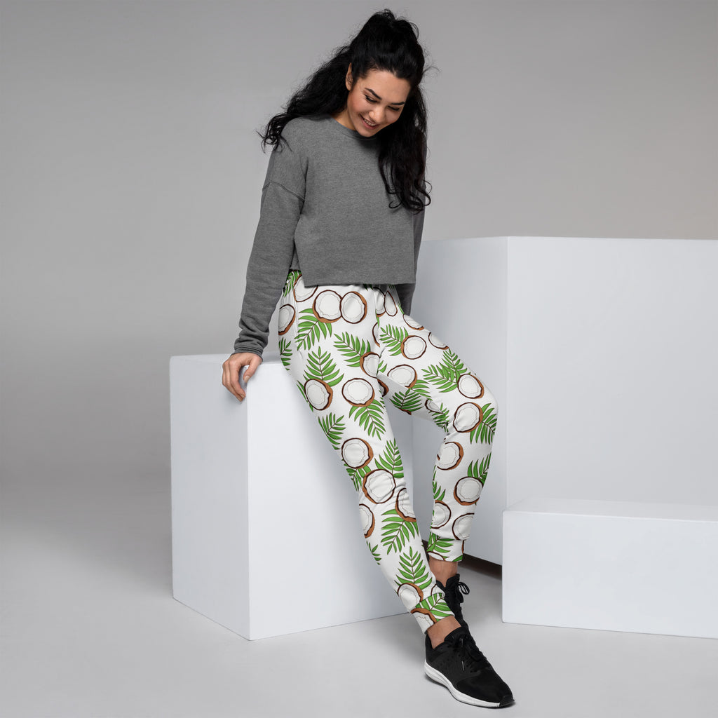 White women’s jogger pants with green palm leaf and brown coconut pattern cozy brushed fleece pockets